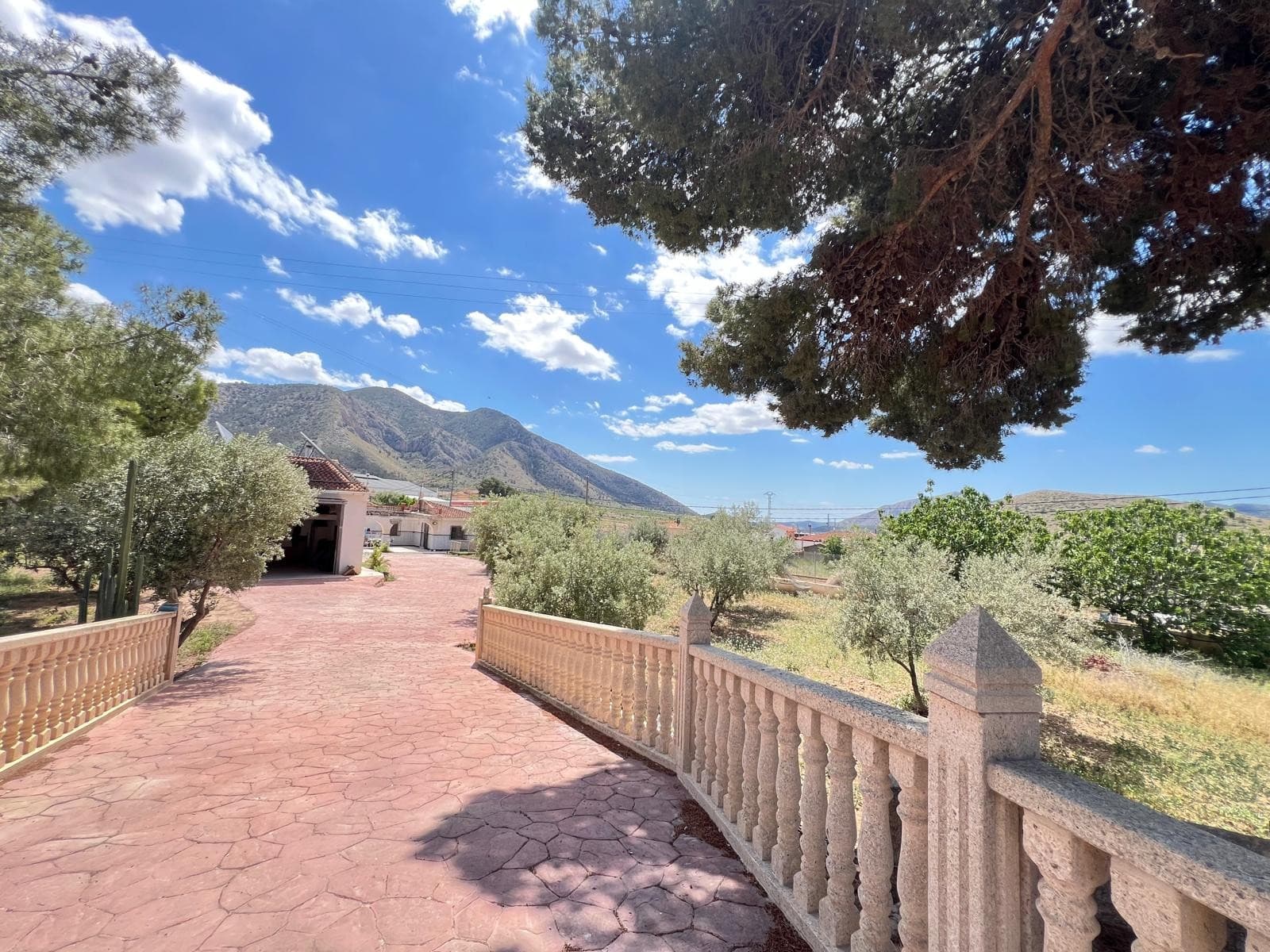 Discover this delightful single-storey home set on a spacious, fully fenced plot in a peaceful area of Algueña. With a secure gated entrance and plenty of outdoor space, this property offers the perfect balance of privacy, comfort, and rustic charm.The house features a generous front porch, ideal for relaxing outdoors, two inviting living rooms each with its own fireplace (one with wood paneling for a warm, cabin-like feel), a fully equipped independent kitchen, two bright and comfortable bedrooms, and a well-maintained full bathroom.A highlight of this property is its private sauna, offering a wellness experience right at home. The plot also includes several outbuildings, including a dedicated animal shelter, ideal for keeping poultry, small livestock or pets. There are also paved outdoor areas suitable for parking, gardening, or entertaining.This property is perfect as a main residence, weekend getaway, or investment opportunity with great potential —All in a quiet yet well-connected location within the village, offering both privacy and convenient access to nearby services-Book your visit today and fall in love with the lifestyle this property has to offer.