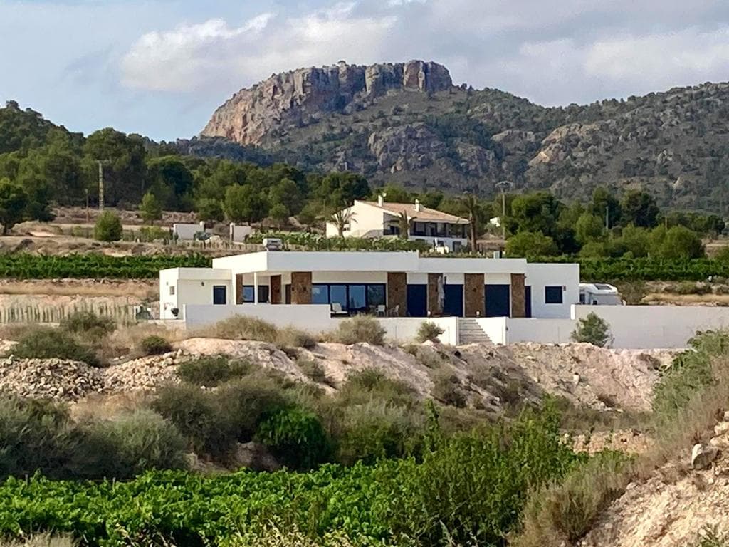 This off-plan villa offers a modern design with a 170 m² build area, featuring two bedrooms, two bathrooms, and a bright open-plan kitchen and living space. The layout is functional and designed for comfortable year-round living. A private infinity swimming pool and a garage is included in the price, as well as a pool room with shower, toilet, sink and space for the pool pump etc. and the home can be customised to suit your needs.The villa will be built on a 10,000 m² plot, which is not included in the base price. We offer a wide selection of over 150 legal building plots across various countryside locations. Plot prices and final costs may vary depending on the location and features chosen.This type of new build is ideal for those seeking space, privacy, and flexibility, while still being within easy reach of towns like Pinoso, La Romana, or Monóvar. These areas are known for their scenic surroundings, vineyards, and traditional Spanish charm, yet they remain close to the coast and Alicante airport. Perfect for full-time living or as a holiday retreat.We have a large portfolio of properties in the Costa Blanca and Costa Calida areas, specialising in country properties, villas, fincas, building plots and design and build options in the Alicante and Murcia regions with a particular emphasis on Elda, Monovar, Pinoso, Sax, Villena, Aspe, Fortuna, Albacete and many more surrounding areas. We have been established since 2004 and have decades of experience between the team which we bring to bear to help you find and secure your new dream home. We help you every step of the way to make sure your purchase in Spain is safe and hassle free. We are not here to sell you a property, we are here to help you realise your dream and find what is right for you. With us you are in the safest hands. Contact us now to have a no obligation chat about how you too can realise your dreams.