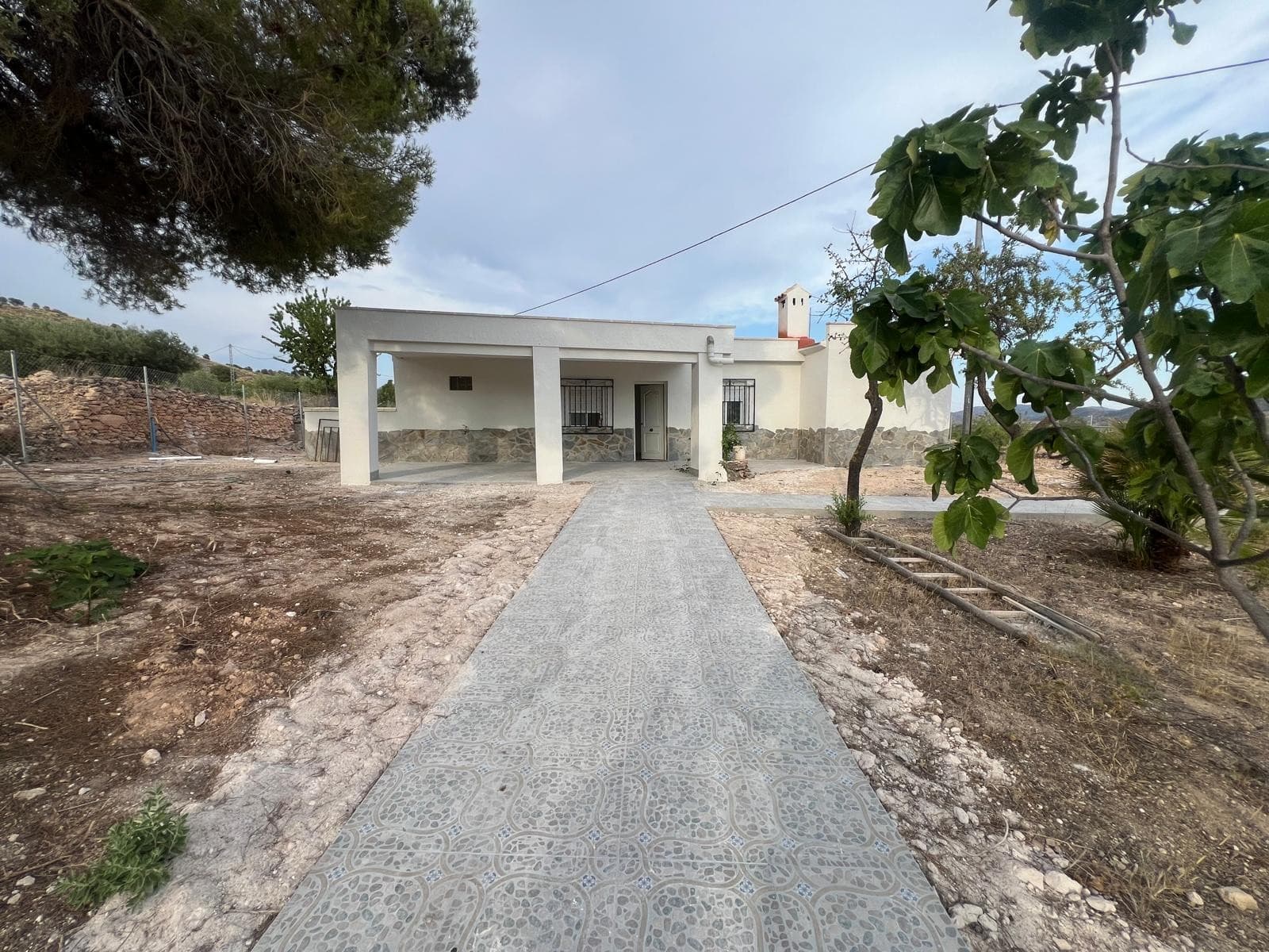 The brand new country house offers 145 m² of living space on a fully fenced 1,500 m² plot with mature olive trees. The property includes four bedrooms and two bathrooms, one of them in suite in the master bedroom. There is also a built-in wardrobe in the master bedroom for added convenience.The bright living room features a wood-burning stove, perfect for cozy winters. The kitchen is spacious and has direct access to the outdoor area, where you can enjoy lovely open views. The house also has an electric boiler.Access to the property is easy, and it is located just 5 minutes from the town of Pinoso, where you will find supermarkets, restaurants, schools, medical services, and everything else you might need for day-to-day living.About the Area:Pinoso is a popular inland town in the province of Alicante, known for its wine production, friendly community, and relaxed lifestyle. It offers a range of services while maintaining the charm and tranquillity of a traditional Spanish village. The surrounding countryside is ideal for outdoor activities like hiking, cycling, and enjoying nature.We have a large portfolio of properties in the Costa Blanca and Costa Calida areas, specialising in country properties, villas, fincas, building plots and design and build options in the Alicante and Murcia regions with a particular emphasis on Elda, Monovar, Pinoso, Sax, Villena, Aspe, Fortuna, Albacete and many more surrounding areas. We have been established since 2004 and have decades of experience between the team which we bring to bear to help you find and secure your new dream home. We help you every step of the way to make sure your purchase in Spain is safe and hassle free. We are not here to sell you a property, we are here to help you realise your dream and find what is right for you. With us you are in the safest hands. Contact us now to have a no obligation chat about how you too can realise your dreams.