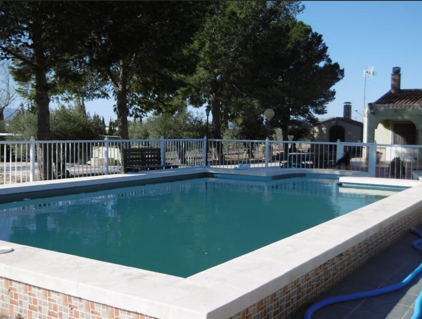 This attractive villa is set on a fully fenced plot of 4,700 m², accessed via a motorized entrance gate for added security and convenience. The property includes a well-maintained 106 m² main house, a 40 m² garage, a 10 m² barbecue area, and a carport with space for up to four vehicles. A standout feature is the fully fenced 50,000-litre swimming pool, equipped with a filtration system—perfect for relaxing and entertaining in the warmer months.The home offers 3 bedrooms, one bathroom, a separate toilet, an independent kitchen, and a spacious dining/living room complete with a wood-burning fireplace and a pellet stove, creating a cosy atmosphere year-round. The floors are finished with durable ceramic tiles throughout.The plot features mature olive and pine trees, creating pleasant natural shade. Property connected to irrigation water and electricity, also has solar panels for cutting down electric bills.This splendid property is offered for a lower price, as it is located close to a highway, mind some noise outside! Located 6 km from the centre of Yecla, with easy access to local amenities.About the area: Yecla is a charming and historic town of app. 35000 inhabitants, located in the region of Murcia. It is renowned for its award-winning wines, historical landmarks, and vibrant local culture. The surrounding natural landscapes of scenic mountains, vineyards and almond groves provide opportunities for outdoor activities, while the town itself offers all necessary services, including hospital, schools, shops, restaurants, and other services. With a friendly local community, lively markets, excellent gastronomy, and easy access to nature, Yecla is an ideal location for those seeking authentic Spanish lifestyle - just about an hour from the coast and Alicante airport.About us: We have a large portfolio of properties in the Costa Blanca and Costa Calida areas, specialising in country properties, villas, fincas, building plots and design and build options in the Alicante and Murcia regions with a particular emphasis on Elda, Monovar, Pinoso, Sax, Villena, Aspe, Fortuna, Albacete and many more surrounding areas. We have been established since 2004 and have decades of experience between the team which we bring to bear to help you find and secure your new dream home. We help you every step of the way to make sure your purchase in Spain is safe and hassle free. We are not here to sell you a property, we are here to help you realise your dream and find what is right for you. With us you are in the safest hands. Contact us now to have a no obligation chat about how you too can realise your dreams.