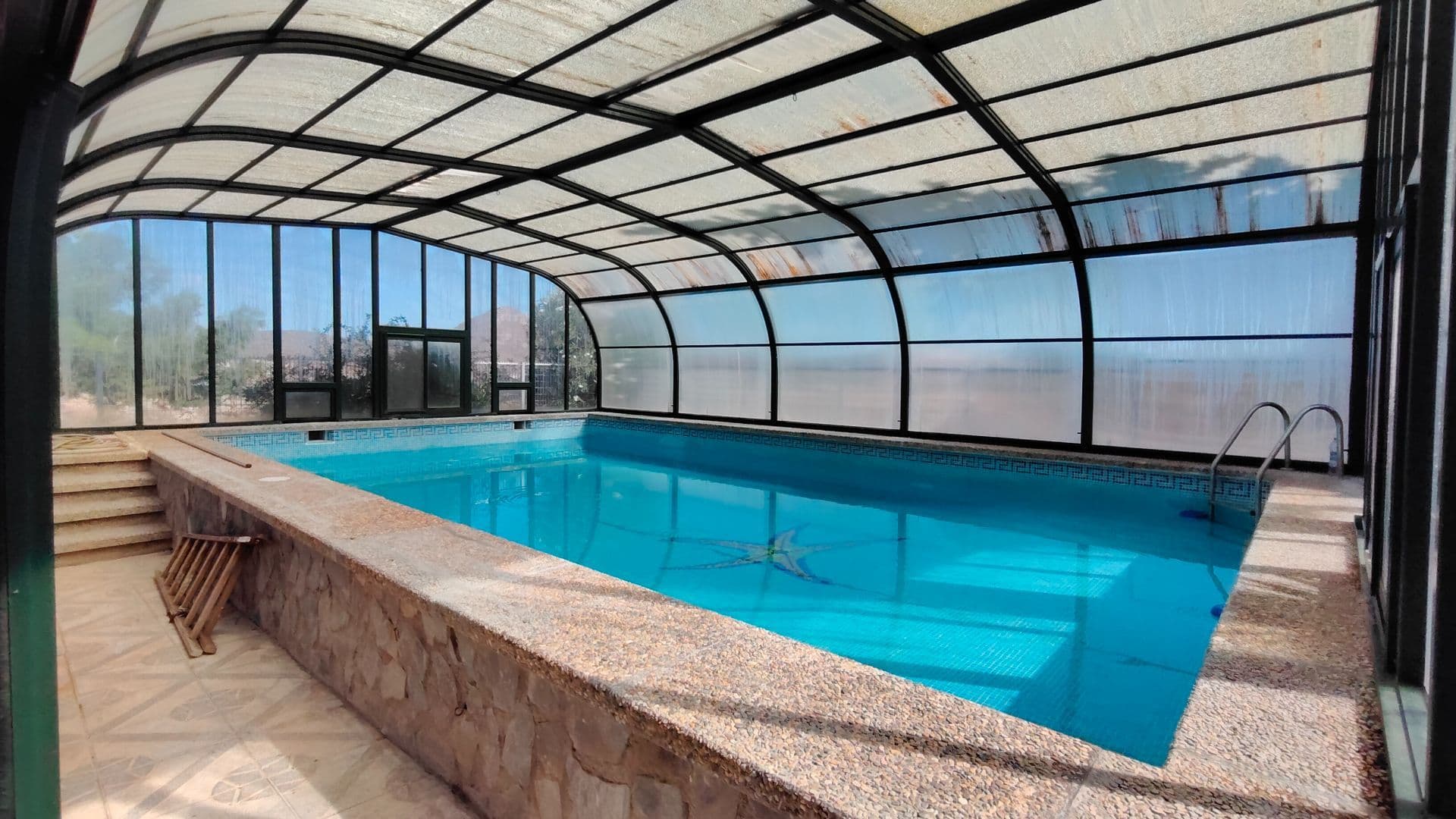 Spacious House with Heated Pool, Outdoor Terrace, and Private Land in Abanilla (Murcia)Located in the municipality of Abanilla, this charming home combines the traditional character of centuries-old buildings with modern comfort and amenities.The main property occupies a 410 m² plot and has a constructed area of 258 m², distributed across three bedrooms, a study with a skylight, a cozy living/dining room, two fully equipped kitchens, and a spacious dining room with a fireplace. It also has three full bathrooms and a guest toilet.On the upper level of the home, there is one of the bedrooms with its own bathroom and access to a solarium with magnificent mountain views, an ideal space to relax and enjoy the tranquility of the surroundings.Among its most notable features is a heated indoor pool, with a green aluminum enclosure and sliding polycarbonate panels, perfect for year-round enjoyment. The home also offers pleasant outdoor areas with a barbecue, a wood-burning oven, large terraces, and an interior patio with a covered gallery, providing a cozy and functional atmosphere.A few meters from the main house is an additional fenced plot of 2,098 m², with a constructed area of 43 m². It includes a room that could be converted into a living space, as well as a storage room and covered parking for two vehicles. The plot features outdoor lighting, a play area, and vegetation with pine trees, centuries-old olive trees, fig trees, almond trees, and other ornamental trees.The property has running water, electricity, and excellent road access, offering a peaceful, well-connected natural setting. It is an ideal option for those seeking a spacious, well-equipped, and charming home surrounded by nature.We have a large portfolio of properties in the Costa Blanca and Costa Calida areas, specialising in country properties, villas, fincas, building plots and design and build options in the Alicante and Murcia regions with a particular emphasis on Elda, Monovar, Pinoso, Sax, Villena, Aspe, Fortuna, Albacete and many more surrounding areas. We have been established since 2004 and have decades of experience between the team which we bring to bear to help you find and secure your new dream home. We help you every step of the way to make sure your purchase in Spain is safe and hassle free. We are not here to sell you a property, we are here to help you realise your dream and find what is right for you. With us you are in the safest hands. Contact us now to have a no obligation chat about how you too can realise your dreams.