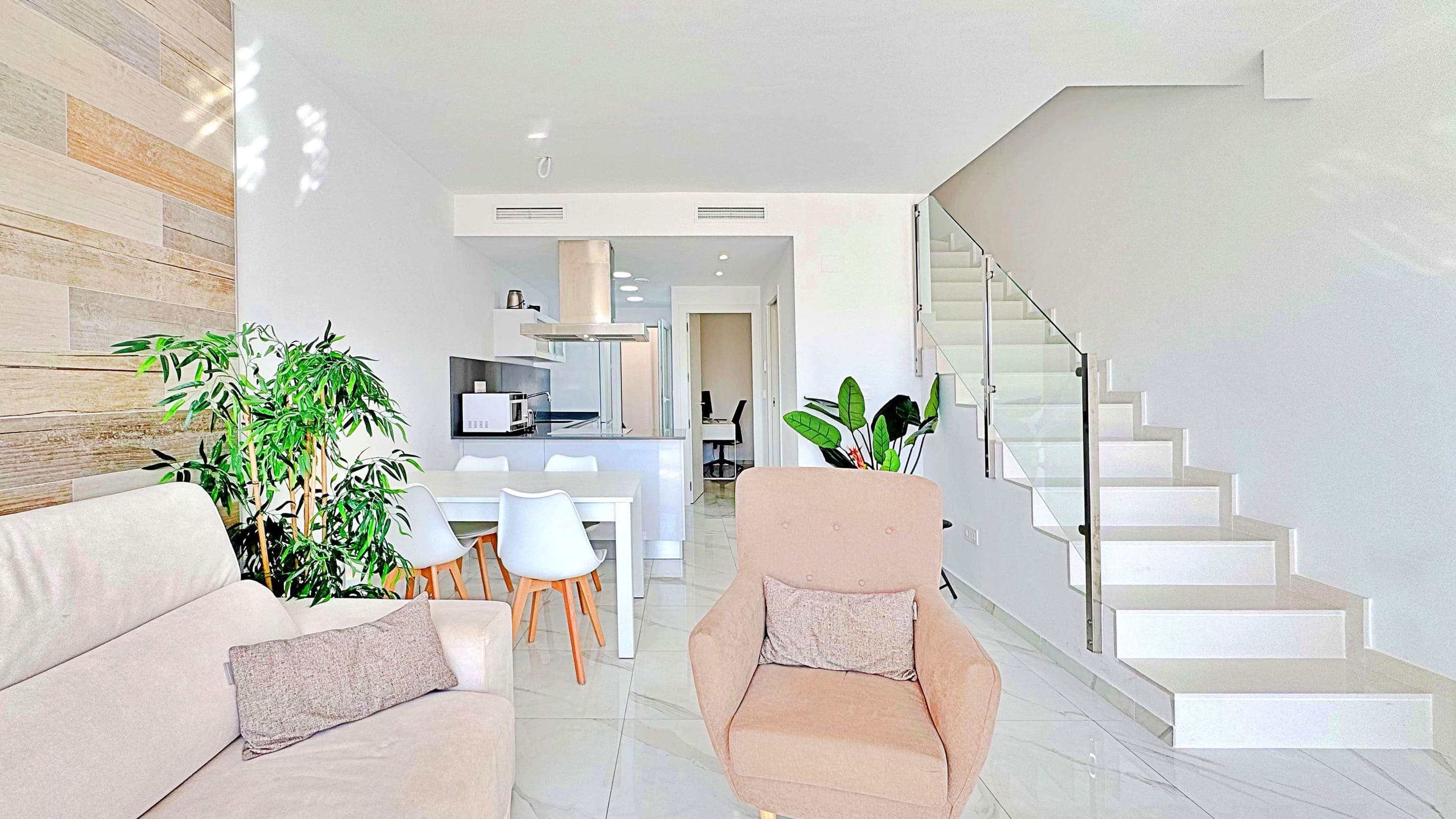 This three-bedroom, three-bathroom duplex townhouse is located in the exclusive residential area of Los Balcones in Torrevieja. The property stands out for its modern design, bright interiors and spacious terraces that allow you to enjoy the Mediterranean lifestyle all year round.On the ground floor, the house features a private 22 m² garden with space for outdoor dining. Inside, there is an open-plan living room with an elegant feature wall, connected to a fully equipped modern kitchen with appliances and breakfast bar. This level also includes a bedroom with fitted wardrobes, currently adapted as a study, and a complete bathroom with shower.Upstairs, there are two further bedrooms, both with fitted wardrobes. The master bedroom is particularly bright and has direct access to a private terrace with views of the residential area and the swimming pool. This floor also offers two additional bathrooms with modern finishes.The property also benefits from a large private solarium with open views of the Torrevieja lagoon, equipped with a chill-out area, pergola, barbecue and sun loungers — perfect for outdoor gatherings or simply relaxing in a peaceful setting.The residential complex offers large communal areas with a swimming pool surrounded by palm trees and green spaces, creating an ideal environment for families or those seeking a relaxed lifestyle.Los Balcones is one of the most established residential areas of Torrevieja, with all services nearby: supermarkets, schools, pharmacies, sports facilities and Torrevieja University Hospital. The beaches of Punta Prima and Torrevieja are less than 4 km away, making this property an excellent choice both as a permanent residence or a holiday investment.