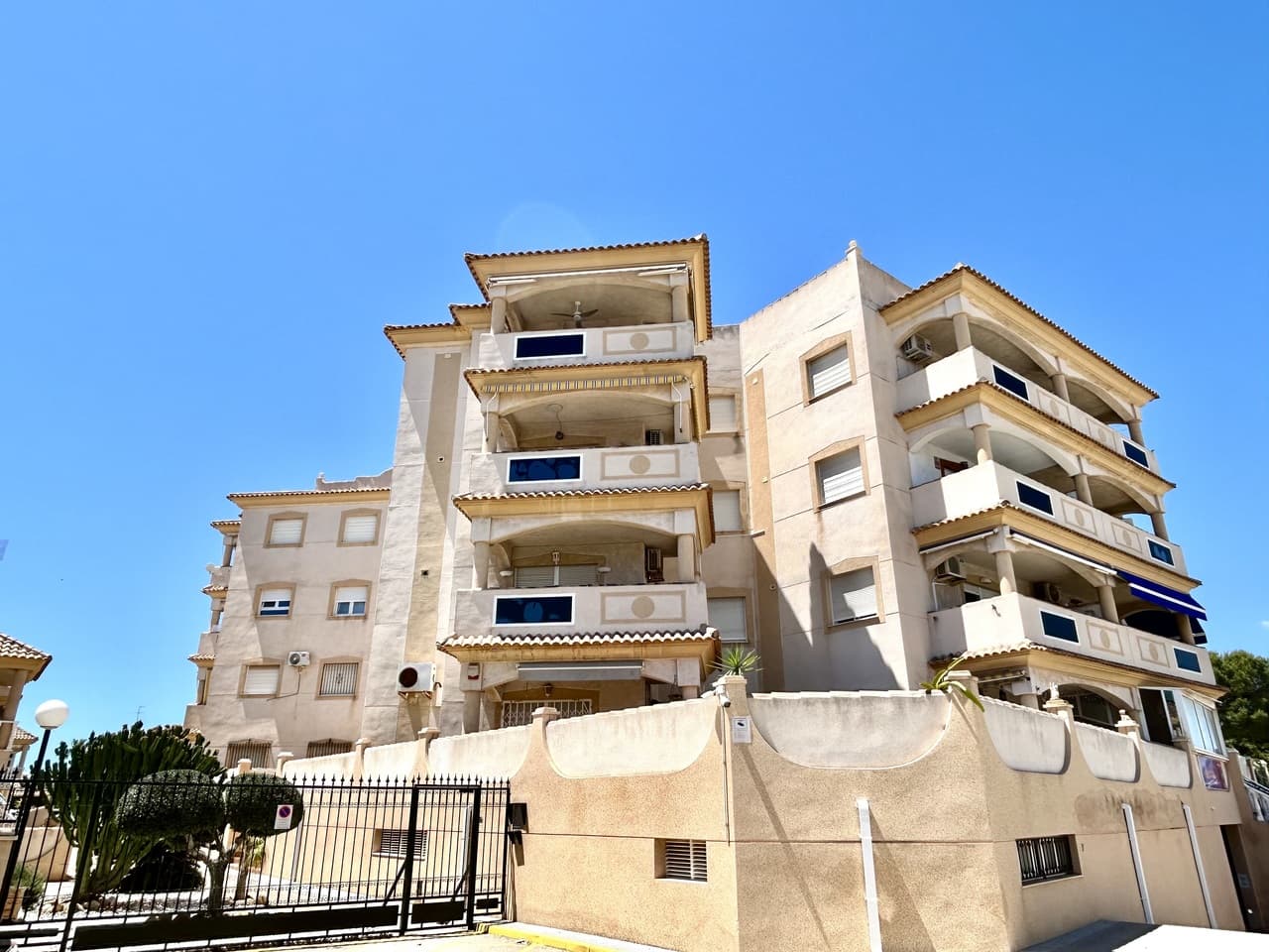 Located in the heart of La Zenia, this 2-bedroom, 1-bathroom penthouse apartment offers a blend of traditional style and a central location. The property is situated in a well-maintained building that includes lift access, a communal roof terrace, and a swimming pool. The interior features a functional open-plan layout with air conditioning and traditional character throughout. A private arched balcony provides sea views, while both bedrooms offer outlooks over a neighboring green park area. The apartment is within walking distance of local bars, restaurants, shops, and the beach, and is also conveniently close to La Zenia Boulevard, schools, and medical facilities. For leisure, several championship golf courses are reachable within a ten-minute drive. With easy access to the AP-7, the property is approximately 50 minutes from both Alicante and Murcia airports.