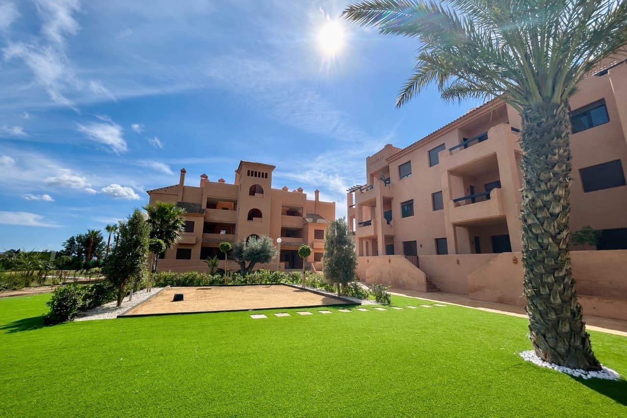This stunning frontline ground-floor apartment is located in the prestigious La Serena Golf resort, offering breathtaking views across the golf course and the sparkling waters of the Mar Menor.Set within a beautifully maintained community, residents enjoy access to a communal swimming pool overlooking the golf course, creating the perfect setting to relax and take in the spectacular surroundings.The property boasts a large private terrace with golf and sea views, an ideal space for outdoor dining, entertaining, or simply enjoying the Mediterranean sunshine.As you enter the apartment, you are welcomed by a spacious entrance hallway that leads into the bright and modern living and dining area, designed to maximise natural light and the incredible views. The home also features a separate fully equipped kitchen, offering both practicality and generous storage space.The apartment offers three comfortable bedrooms, including a master bedroom with its own en-suite bathroom. The two additional bedrooms share a modern family bathroom, making the layout perfect for families or visiting guests. One of the guest bedrooms also provides direct access to a sunny rear terrace, adding another private outdoor space to enjoy.Additional features includes a private parking space in the underground garage and a storage room, providing excellent convenience and extra space.Located just minutes from the beaches, restaurants, and marina of Los Alcázares, this exceptional apartment offers the perfect combination of luxury living, stunning views, and an unbeatable golf-front location.A fantastic opportunity for a permanent residence, holiday home, or investment property on the beautiful Costa Cálida.