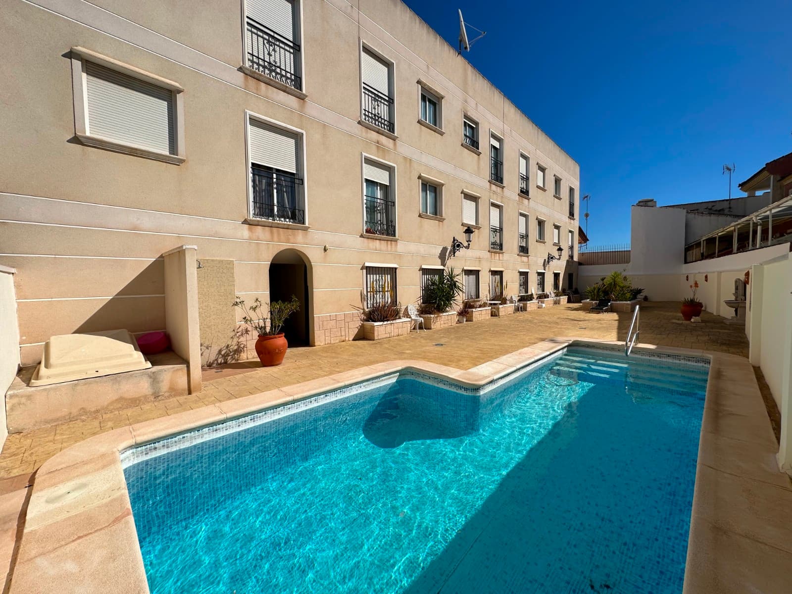 New listing ! Located within the secure and well-maintained Residencial Marquesas 2 development in the charming village of Jacarilla, this attractive first-floor apartment offers comfortable Mediterranean living in an excellent setting. The gated community features beautifully kept communal areas and access to a lovely residents’ swimming pool, ideal for relaxing in the Spanish sunshine. The property boasts a bright and spacious open-plan living area with lounge, dining space, and fitted kitchen, creating a modern and sociable layout perfect for everyday living or holidays. Large doors open onto a private balcony, providing a pleasant outdoor space for morning coffee, al fresco dining, or simply enjoying the warm climate. There are two well-proportioned bedrooms and two bathrooms, offering both comfort and practicality. The master bedroom benefits from its own en-suite bathroom, while the second bathroom serves guests and the second bedroom. Both bedrooms provide a welcoming retreat with good natural light and built-in storage potential. Ideally situated close to local amenities and just a short drive from the Costa Blanca beaches, this apartment would make an ideal permanent residence, holiday home, or rental investment in a peaceful yet convenient location