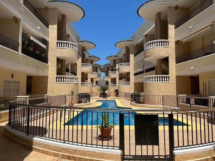 A well-presented top-floor apartment located in the sought-after village of Jacarilla, Alicante, set within the secure and well-maintained Marquesas IV complex.This bright and spacious property offers two comfortable bedrooms and two modern bathrooms, making it ideal for both holiday use and year-round living. Positioned on the top floor, the apartment benefits from added privacy and enjoys plenty of natural light throughout.The living area opens onto a private balcony, perfect for relaxing or dining outdoors, while an internal staircase leads up to a generous private solarium. This rooftop space is ideal for sunbathing, entertaining, or simply enjoying panoramic views of the surrounding area.The apartment is sold fully furnished, allowing for an easy move-in or rental opportunity. It is also equipped with air conditioning, ensuring comfort during the warmer months.Residents of the Marquesas IV complex benefit from access to a well-kept communal swimming pool, landscaped areas, and the added security of a gated community. The property also includes a designated parking space, providing convenience and peace of mind.Located within walking distance to local amenities and just a short drive from the beaches of the Costa Blanca, this apartment combines comfort, practicality, and an excellent location.
