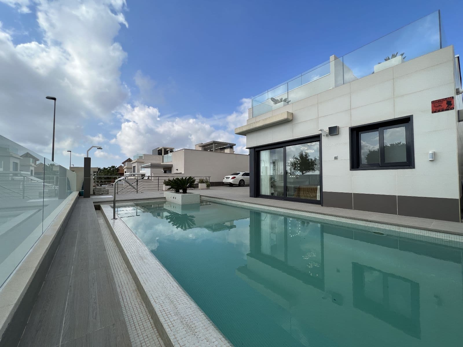 This luxurious modern villa spans three levels and features 5 bedrooms and 4 bathrooms, with and a stunning glass staircase with built-in led accent lighting and a convenient commercial elevator that seamlessly connect all floors.Nestled in the Las Comunicaciones neighborhood, the property is perched on a hill, offering stunning open views of the salt lake and coastline beyond. It’s just a 2-3 minute drive to the town center of San Miguel de Salinas, while Villamartin / Orihuela Costa are only 7 minutes away, providing easy access to all the amenities and attractions of the Costa Blanca South coastline.The villa features 5 bedrooms and 4 bathrooms, spread across two floors and a XL basement. The villa is being sold furnished.The ground floor welcomes you with an open-concept design includes a top of the line kitchen with central prep island, spacious dining area, large living space that looks out to the pool and separate laundry room off of the kitchen with storage. Also on this level you will find the master bedroom with views to the pool area, this spaces exudes style and comfort plus includes a large en-suite bathroom and walking closet/dressing room .The basement is designed for entertainment, with second full kitchen with breakfast bar, large living / home theater room, 2 bedrooms, 1 bathroom with tub and large storage room/wine cellar.Upstairs you will find a further 2 en suite bedrooms both with access to terrace and access to the solarium. All levels with fantastic open views.The garden features BBQ / Outdoor kitchen area, private pool with waterfall. Plenty of off street parking space on this gated secure private plot. Contact us today for further details and to book a viewing on this very special Luxury Family Villa!
