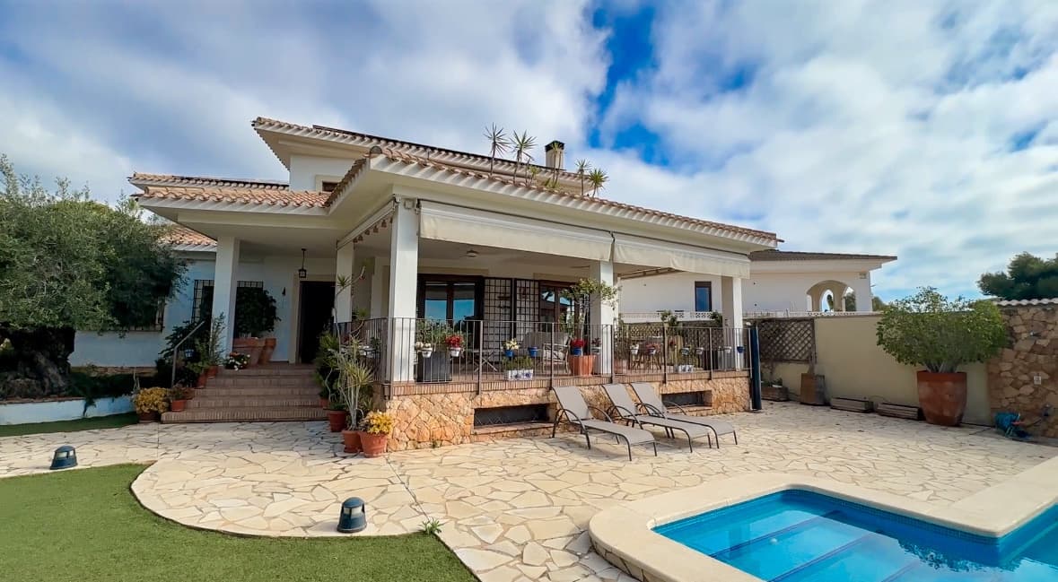 This exceptional Mediterranean-style villa is ideally located just 800 metres from the sea, in one of the most prestigious residential enclaves of Dehesa de Campoamor, on the sought-after Orihuela Costa. Combining expansive living spaces, complete privacy, and high-end finishes, the property is perfectly suited as a permanent residence, an elegant holiday home, or a luxurious coastal retreat.Set on a private plot of 725 m², the villa offers an impressive 450 m² of built living space distributed across three levels: basement, ground floor, and first floor. Its south-facing orientation უზრუნველყოფ ensures abundant natural light throughout the day while allowing year-round enjoyment of the Mediterranean climate.Originally built in 2006, the property was fully renovated in 2020. This comprehensive upgrade included new bathrooms, redesigned bedrooms, and a completely modernised kitchen, achieving contemporary comfort while preserving the villa’s distinctive Mediterranean charm.The residence features a total of 7 bedrooms and 5 bathrooms, thoughtfully distributed across the three levels:Basement: 2 bedrooms and 1 bathroomGround floor: 3 bedrooms and 2 bathroomsFirst floor: 2 bedrooms and 2 bathroomsThe upper level hosts a stunning 32 m² master suite, bathed in natural light and complemented by a private en-suite bathroom and a spacious walk-in wardrobe, creating a refined and tranquil private sanctuary.The outdoor spaces are designed to fully embrace Mediterranean living. A beautifully landscaped garden with mature trees and flowering plants surrounds a private 27 m² swimming pool—perfect for relaxing in total privacy or entertaining guests in style.The property also includes a large garage with capacity for three full-size vehicles.At the heart of the home is a generous 23 m² kitchen, completely renovated in 2020 and fitted with premium furnishings and finishes from the renowned European brand Schmidt. It offers a perfect blend of elegance, space, and functionality for both everyday living and entertaining.Additional features include:Air conditioning (hot and cold) on the ground and first floorsSolar panel system producing approximately 10 kW/h, enhancing energy efficiencyElectric vehicle charging stationEnergy certificatePerimeter alarm system with video surveillanceCorner plot position, providing enhanced privacyTerracotta flooring throughout, reinforcing the Mediterranean characterHandcrafted wrought-iron railings from Toledo, adding distinctive architectural detailThe villa also benefits from access to an exclusive private community area reserved for homeowners in Dehesa de Campoamor, offering excellent leisure and social facilities, including:Three tennis courtsOne paddle courtTwo football pitchesSemi-Olympic swimming poolPrivate residents-only cantina/restaurant, fostering a welcoming and social community atmosphereThis is a rare opportunity to acquire a spacious, fully renovated Mediterranean villa close to the sea in one of the most desirable areas of the Costa Blanca—offering an exceptional combination of comfort, sustainability, privacy, and premium lifestyle amenities.