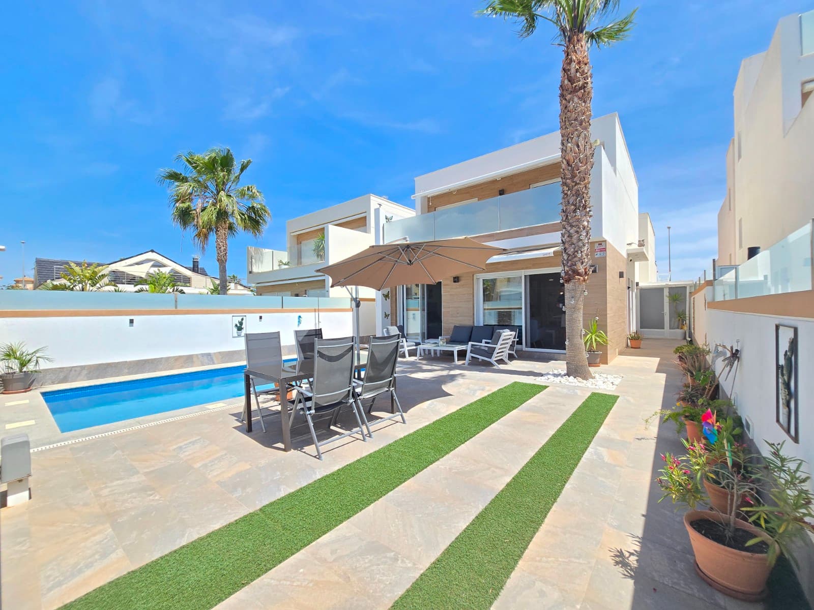 Discover this beautiful detached villa, ideally situated in the centre of Pilar de la Horadada, within walking distance of shops, lively bars and excellent restaurants. What’s more, the beach is just a short distance away and easily accessible via a pleasant walking and cycling path.The villa features 3 spacious bedrooms and 2 modern bathrooms. The master bedroom includes a stylish walk-in wardrobe, providing extra comfort and storage space. On the first floor is a large terrace where you can relax and enjoy the pleasant climate.The property offers a bright and spacious living room with an open-plan kitchen, ideal for cosy moments with family and friends. Thanks to its south-west facing position, you can enjoy natural light all day long and stunning sunsets.Outside, you’ll find a private swimming pool with a built-in jacuzzi bench, surrounded by a spacious garden where you can relax in complete privacy.In addition, the villa is equipped with numerous extras that ensure extra comfort and security, such as electric shutters, awnings, a water softener, an intercom, an alarm system and underfloor heating combined with electric heating in the bathrooms. Furthermore, the property offers plenty of storage space thanks to a practical storage room under the stairs and an outdoor storage area with an adjoining laundry room.In short, a ready-to-move-in property that perfectly combines luxury, comfort and a prime location, with both the town centre and the beach within easy reach.Suma: 633 euros / year.