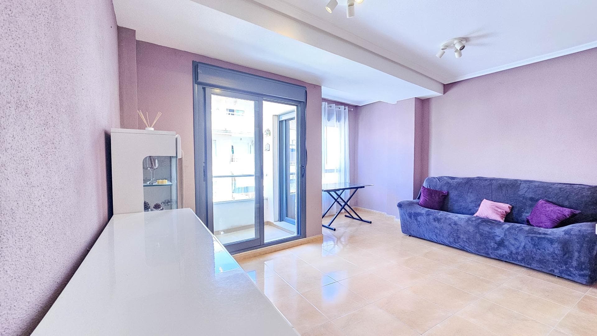 A two-bedroom, two-bathroom apartment is for sale in the center of Torrevieja at 14 Calle San Luis. The apartment is located on the 5th floor of a six-story building built in 2002 with an elevator. The windows face west. The apartment has 80.30 m² of total area and 76 m² of living space. It consists of a hallway at the entrance, which then branches off to the right and left. To the right is a spacious living room with a breakfast bar, a fully equipped American kitchen, and a balcony overlooking the Pink Lake. To the left is a sleeping area consisting of two separate bedrooms: a master bedroom with a bathroom and dressing room, and the second bedroom with a large built-in wardrobe and shower room. It is sold in very good condition, with split air conditioning in the living room, set for "hot and cold," fully furnished and with all appliances. Price: €144,000.