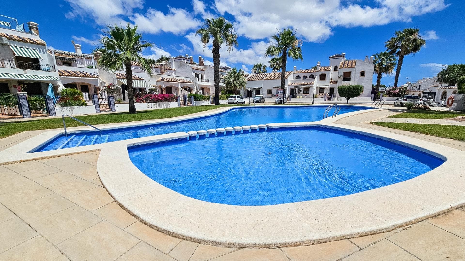 A two-bedroom, two-bathroom townhouse on three levels is for sale in a condominium with parking, a swimming pool, and a subtropical garden in the PAU-8 area (Calle La Dolores) in VillaMartin. Picturesque condominium near the canal, four golf courses, and the VillaMartin shopping center. Respectable European neighbors. Annual condominium fees are €550. A gardener is on hand to maintain the parking, pool, and lighting. The house faces west and east, enjoying full sunlight throughout the day. The total living area is 87 m². The ground floor consists of a living room with a fireplace and a fully furnished and equipped American kitchen with a breakfast bar, along with a bathroom. A marble staircase leads to the second floor. The second floor features two separate bedrooms with built-in wardrobes and a spacious full-size bathroom. The third level features a spacious solarium with a barbecue and a sink. The house has two entrances: one from the condominium and one from the entrance garden.