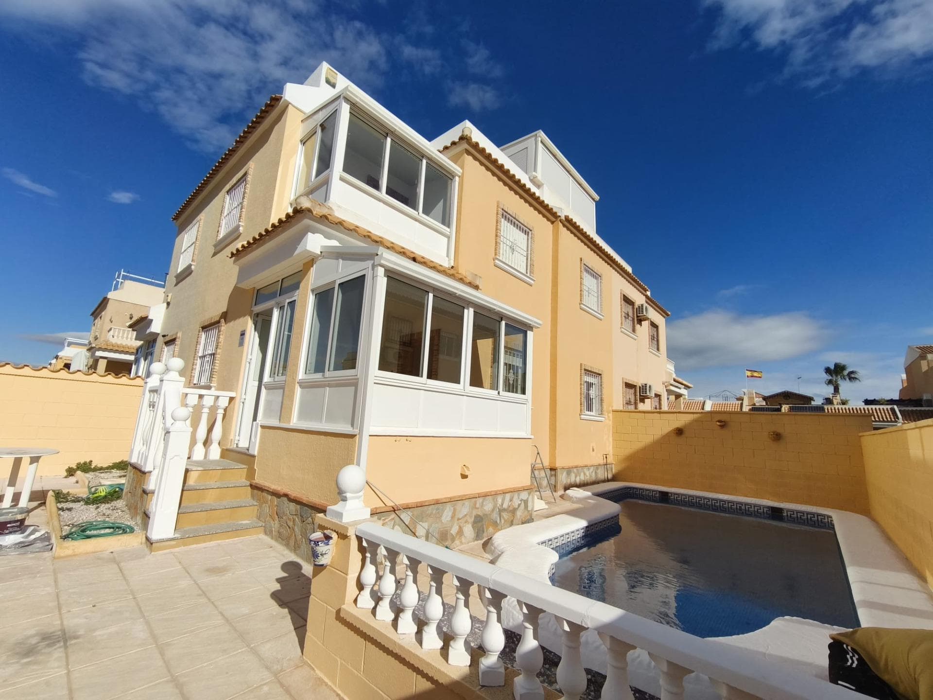 This fully renovated semi-detached house in Lo Marabú is ready to move into and is located in a quiet residential complex with two communal swimming pools. A bright, comfortable, and fully equipped home, designed to enjoy the Mediterranean climate both indoors and in its pleasant outdoor areas. The property is distributed over two floors plus a solarium. On the ground floor, with direct access from the street, there is a private plot with a garden and its own pool, perfect for relaxing, sunbathing, or enjoying time outdoors. A closed, glass-enclosed entrance hall leads to the living-dining room, a welcoming space with plenty of natural light. The completely renovated and brand-new kitchen features new cabinetry, upper and lower units, a black marble countertop, and a stainless steel extractor hood. A full bathroom is also located on this floor. On the first floor, there are three bedrooms, including the master bedroom, which has a built-in wardrobe and access to a terrace. This floor also features a second full bathroom and a glazed terrace with direct views of the plot and the private pool, a versatile space that can be enjoyed year-round. The second floor offers one of the property's greatest attractions: a spacious 25 m² outdoor solarium, ideal for creating a relaxation area, outdoor dining space, or leisure area. It also includes an enclosed, glazed 8 m² turret-style solarium, perfect as a chill-out zone, office, reading nook, or additional living space. This fully equipped, renovated home boasts a private pool, garden, terraces, and solarium, and is located in a quiet residential area with the added benefit of communal swimming pools. It is ideal as a permanent residence, a second home, or an investment property on the Costa Blanca. Contact us for more information or to schedule a visit and discover everything this property has to offer.
