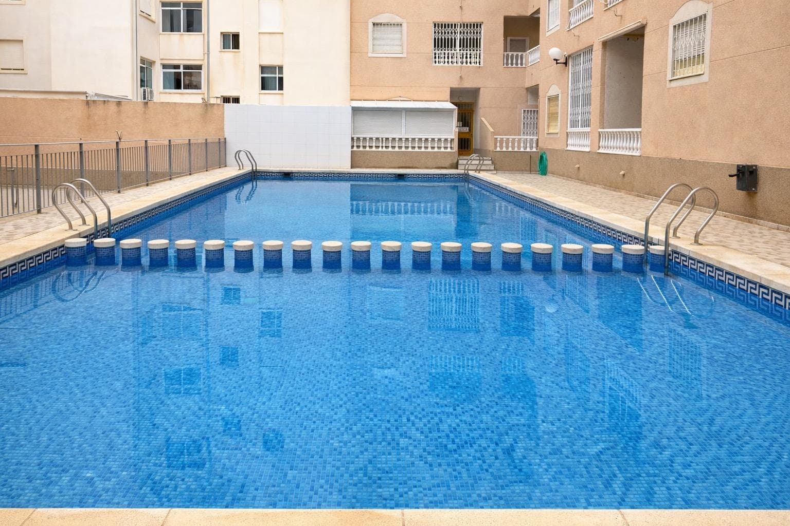 Just 600 meters from Playa del Cura, this apartment combines three of the most sought-after features in Torrevieja: a prime location, a communal pool, and a comfortable layout designed for immediate enjoyment. This property is ideal for those who want to live near the sea, spend time on the coast, or invest in an area with year-round demand. With 68 m² of living space, the apartment offers well-utilized rooms and a practical layout. It features a bright living-dining room, a separate kitchen, a full bathroom, and two bedrooms, making it a versatile option for couples, small families, or those seeking a comfortable second home by the Mediterranean. Furthermore, it boasts double-glazed windows, an upgrade that provides enhanced thermal and acoustic insulation, contributing to a more peaceful and comfortable environment. The apartment is located in a building constructed in 2000, with an elevator and a communal pool—two highly valued features in this area. This residential complex offers the comfort of living in a well-established neighborhood with reasonable expenses: quarterly community fees of €52.77 and annual property tax (IBI) of €205.11. Its location puts everything within easy reach: Playa del Cura beach is just a few minutes' walk away, and shops, supermarkets, restaurants, leisure areas, and essential services are all nearby. It's an ideal area to enjoy Torrevieja without constantly relying on a car, with the sea close by and daily life taken care of. This well-balanced, comfortable home has great potential for those seeking location, amenities, and quality of life near the beach. Contact us for more information or to schedule a viewing.