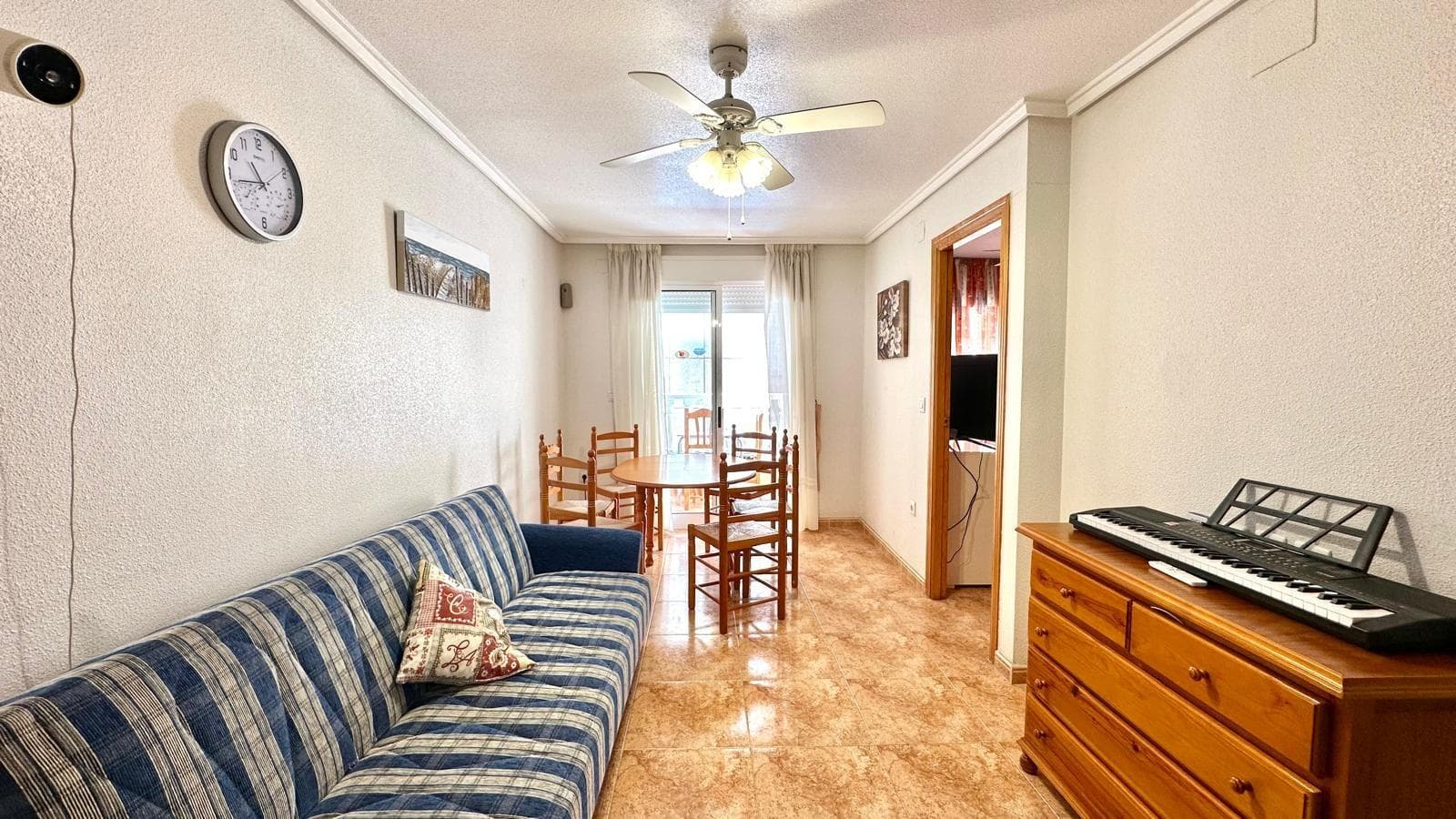 This is an excellent opportunity to purchase an attractive first-floor flat situated in the well-established Parque de las Naciones area of Torrevieja, in a prime location close to La Acequión. This strategic location allows you to enjoy a peaceful residential setting without sacrificing proximity to the sea, as the property is just 500 metres from the beach, offering quick and easy access on foot. The property is situated in an area highly valued by both residents and visitors alike, thanks to its proximity to all essential amenities. In the immediate vicinity, you will find supermarkets, shops, restaurants, medical centres, public transport and various leisure facilities, ensuring a comfortable and convenient lifestyle all year round. The property, situated on the first floor, offers a functional and well-designed layout. It features two bedrooms, each with its own distinct layout and characteristics. The first is a single bedroom, ideal as a spare room, study or guest room, which opens directly onto a light well, providing natural ventilation and a brighter atmosphere. The second, larger bedroom is a double room facing outwards, notable for its south-facing aspect, which provides excellent natural light for much of the day, creating a warm, pleasant and comfortable space. The flat also features a terrace, a particularly valued feature that allows you to enjoy the Mediterranean climate in a private setting. This outdoor space is ideal both for moments of relaxation and for sharing meals al fresco, becoming a natural extension of the home. The property forms part of a residential community featuring a communal swimming pool, an additional attraction that significantly enhances the quality of life, particularly during the warmer months. This communal space is designed for enjoyment and relaxation, offering a well-maintained and pleasant environment for all residents. In terms of its condition, the property is well maintained, allowing for immediate occupancy without the need for major refurbishment. This makes it a particularly attractive option both for those seeking a primary residence and for those interested in a second home or an investment with potential for profitability in the holiday rental or long-stay market. It is worth highlighting the excellent combination of location, aspect, layout and amenities offered by this apartment. Its proximity to the beach, good links to the rest of the city and the availability of all amenities within a few minutes’ walk position it as a highly competitive option within the local property market. Overall, this property represents a solid and attractive opportunity for those wishing to enjoy the Mediterranean lifestyle in a comfortable, well-connected setting with all amenities within easy reach. An apartment that offers the ideal conditions both for personal enjoyment and as a secure investment in one of the most sought-after areas on the coast.