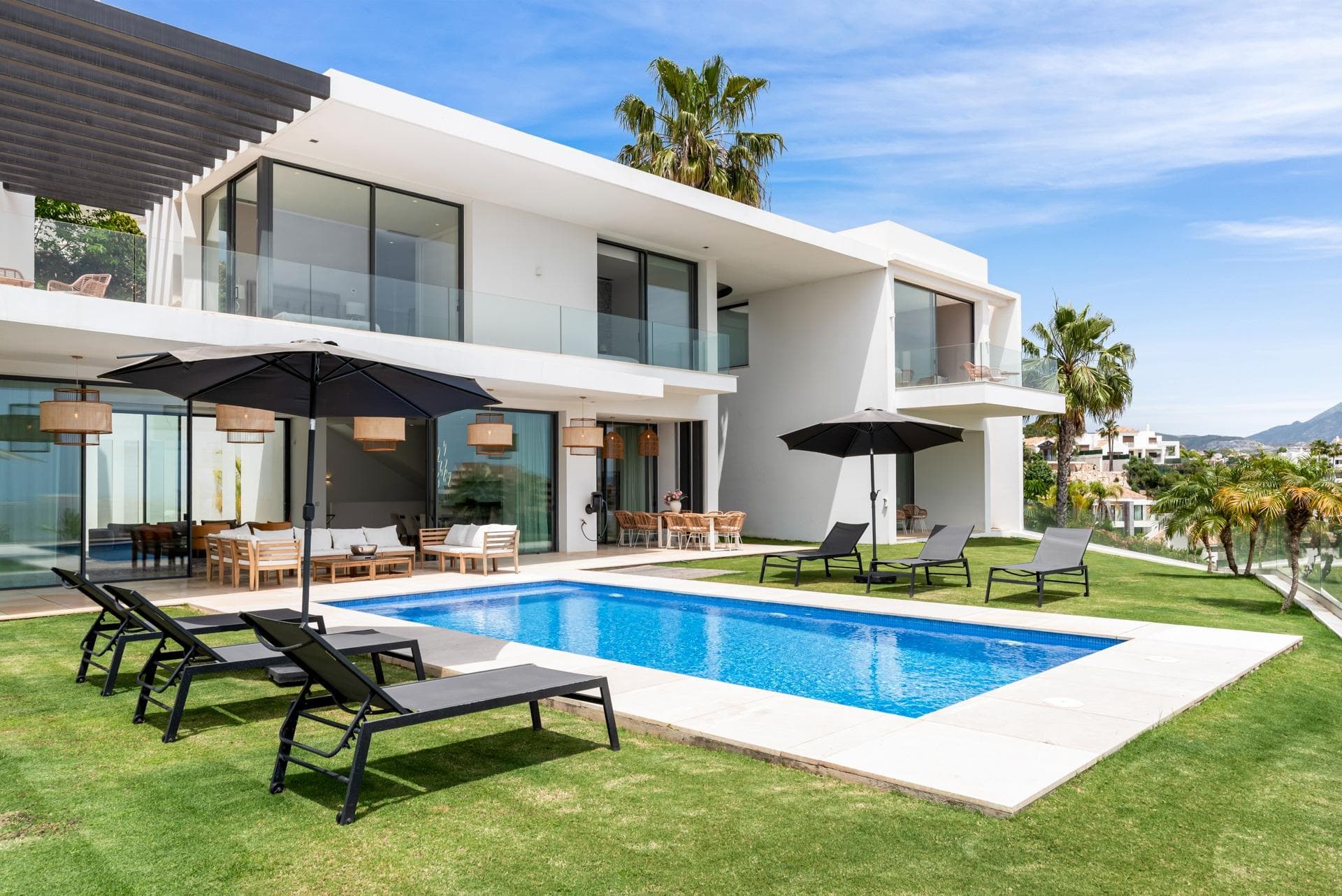 This contemporary, high-quality modern villa is situated in the highly sought-after residential area of La Alquería, Benahavís. South-facing and perfectly positioned, the property commands breathtaking, panoramic views of the Mediterranean Sea and surrounding mountains. Enjoying an ideal location, it sits just minutes away from local amenities, championship golf courses, and a short 5 to 10-minute drive from the beach and San Pedro town center. Main Floor: Features an expansive living and dining area seamlessly integrated with an open-plan, fully-fitted kitchen. Large sliding glass doors flood the space with natural light and open directly onto covered and uncovered terraces. The outdoor area is a private oasis, boasting beautifully landscaped gardens, dedicated chill-out zones, a BBQ area, and a stunning swimming pool. This level also includes one en-suite guest bedroom and a guest toilet. Upper Floor: Dedicated to rest and relaxation, featuring an elegant master bedroom suite alongside two additional guest bedrooms, both with en-suite bathrooms. All bedrooms enjoy direct access to private terraces with spectacular, unobstructed views. Basement Level: Offers exceptional versatility, comprising an additional guest bedroom with its own sitting area and terrace, a practical laundry room, and a massive entertainment space—perfect for a private gym, home cinema, or games room. A spacious underground garage accommodates 5 to 6 vehicles. An exceptional modern family home that perfectly combines luxury, privacy, and space in one of Benahavís’ most prestigious locations.