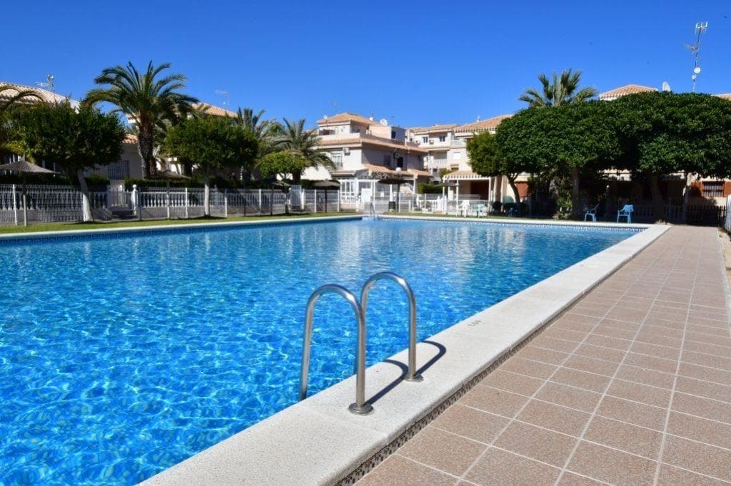 A wonderful ground floor 2-bedroom bungalow with a patio and pool in Playa Flamenca Located in a gated community that is well-maintained and features pleasant landscaped areas next to a communal pool, this home offers a peaceful and comfortable setting. It boasts 65 square meters of living space, perfectly laid out to make the most of every area. Upon entering the property, you’ll find a spacious private outdoor patio, ideal for enjoying the outdoors year-round. Inside, the home features a bright living-dining room equipped with air conditioning, which flows seamlessly into a practical kitchen with a breakfast bar, creating a functional and cozy atmosphere. It also includes two bedrooms, a full bathroom, and an additional room used as a pantry, providing much-appreciated extra storage space. The property is in good condition, ready to move into without the need for renovations. Thanks to its location and features, it represents a particularly attractive option for vacation or residential rentals in a high-demand area. LOCATION: Playa Flamenca is primarily an exclusive residential area with all necessary and comfort surrounded by greenery. Surrounded by good restaurants by the sperfect place to rest. It has good connections both by road and National ea, it is the Highway. Also, well served by buses and taxis. It has both sandy beaches and rocky coves. The closest hospital is the Hospital Universitario de Torrevieja (4 km away) and within minutes you can find the Hospital Quirónsalud Torrevieja. It is also close to airports such as Region of Murcia International Airport (35 km away) and Alicante Airport (47 km away). DISTANCE TO THE SEA: 1000m Community fees: €91 every 6 months Property tax: €119 Garbage collection: €69 Should you have any question do not hesitate to contact us!