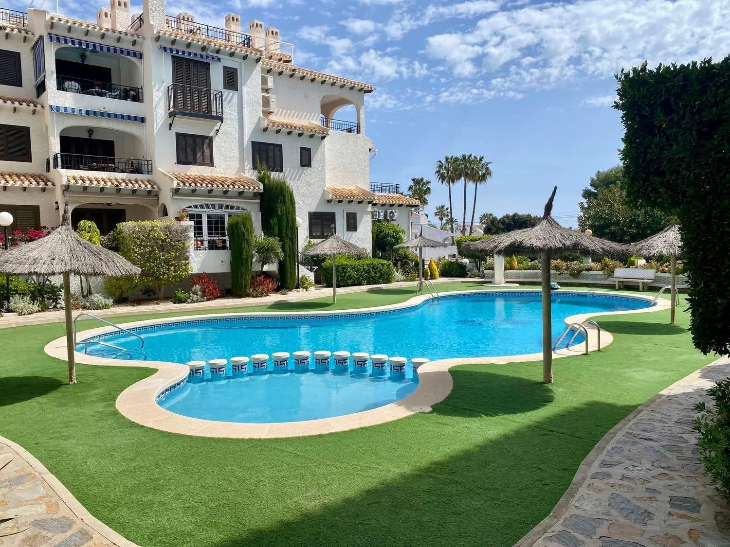 MEDITERRANEAN APARTMENT WITH LARGE TERRACE, POOL AND SEA VIEWS IN CABO ROIG Discover this charming apartment located in one of the most sought-after and well-maintained residential complexes in Cabo Roig, just 500 metres from the beach and the Mediterranean Sea. Set in a quiet and exclusive area, this property combines natural light, comfort and authentic Mediterranean style, making it ideal as a permanent residence, holiday home or investment opportunity. The apartment offers a comfortable and welcoming layout. Upon entering, you are greeted by a bright living-dining room with fireplace, perfect for enjoying all year round. From here, you access a fantastic southwest-facing terrace of approximately 15 m², ideal for sunbathing, outdoor dining or relaxing while enjoying the excellent Costa Blanca climate. Both the entrance and the terrace offer pleasant open views towards the communal pool and the Mediterranean Sea. The open-plan kitchen is fully equipped and also benefits from a practical separate utility/laundry area. The property features: 2 spacious bedrooms with fitted wardrobes Air conditioning in the bedrooms 1 fully equipped bathroom Large sunny terrace Fireplace Fibre optic internet installed Fully furnished and equipped Ready to move into The residential complex stands out for its charming Mediterranean architecture, landscaped gardens and beautiful communal swimming pool with relaxation areas, creating a peaceful and welcoming atmosphere all year round. Its excellent location allows easy walking access to beaches, restaurants, cafés, supermarkets and all essential services. Cabo Roig is one of the most exclusive and desirable areas of Orihuela Costa, famous for its crystal-clear beaches, marina, international atmosphere and excellent connections to Alicante and Murcia airports. A property full of charm, sunshine and sea views, perfect for enjoying the Mediterranean lifestyle.
