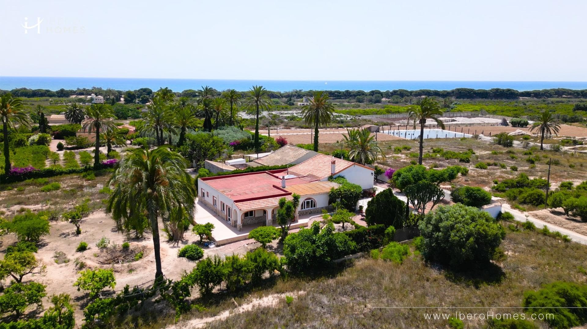 Discover this jewel of traditional Spanish style, a single-storey villa located in a privileged and very quiet area and with a path that leads right down to the sea. . A unique opportunity to acquire a charming property, surrounded by nature and with multiple possibilities.. . The villa is located on a plot of more than 3.000 m2, full of palm trees and fruit trees that create a private, natural and very special environment. It has 5 large bedrooms, 2 complete bathrooms and 1 toilet, a very spacious independent kitchen, as well as a bright and spacious living-dining room ideal for family gatherings or moments of relaxation.. . One of its great attractions is the beautiful covered terrace, perfect for enjoying the Mediterranean climate all year round. Equipped with barbecue and grill, it becomes the ideal place to share unforgettable meals and dinners outdoors.. . In addition, the property has an unfinished outbuilding, which offers the possibility of adding up to 4 additional bedrooms and 4 bathrooms, which opens up a range of opportunities for both residential use and tourist exploitation or investment: perfect to be transformed into a charming rural hotel.. . It has covered parking space for two vehicles and the possibility of extending it.. . Located in a protected area where building is not allowed, this house guarantees privacy, exclusivity and a unique connection with nature without renouncing to the proximity of the beach.. . Ideal as a permanent residence, second home or tourist project, this property has all the ingredients to become a safe and valuable investment.. . Take advantage of this unique opportunity and request a visit to this paradise.