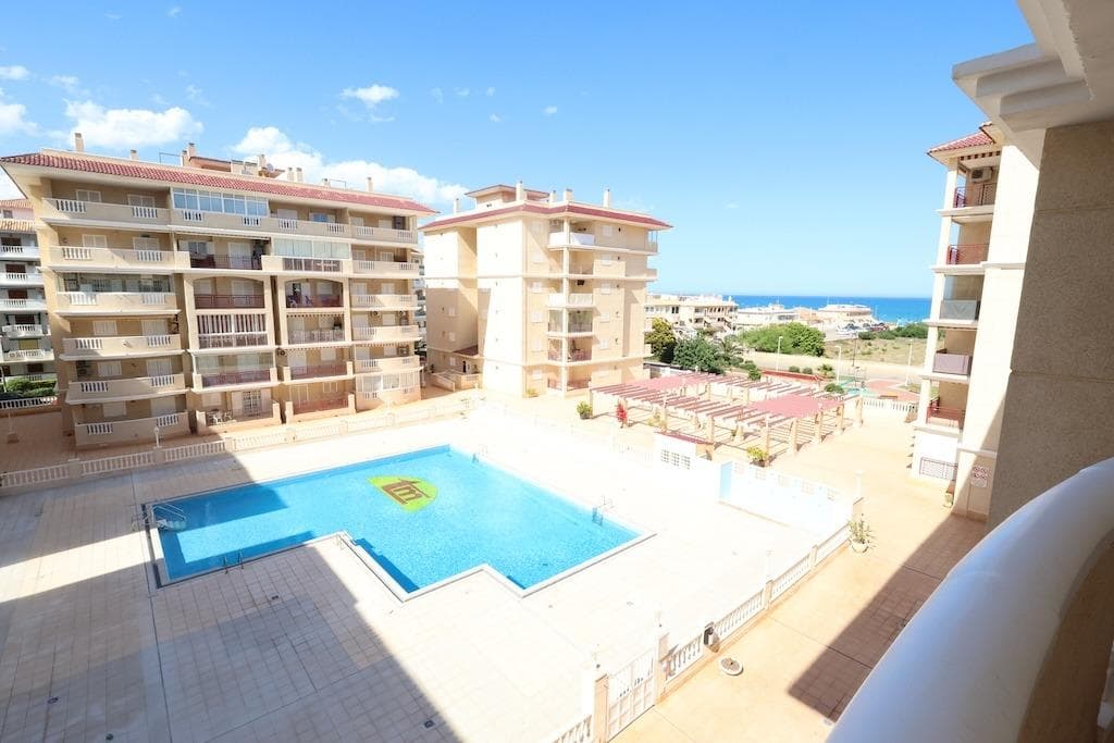 La Mata, Residencial Viña Mar VII. 3rd-floor apartment (with elevator) just 200m from the beach. This 67m2 property features 2 bedrooms, 1 bathroom, an open-plan kitchen, and a living-dining area. It boasts a large 8m2 terrace with views of the communal pool and the sea. Sold semi-furnished and includes a garage space.