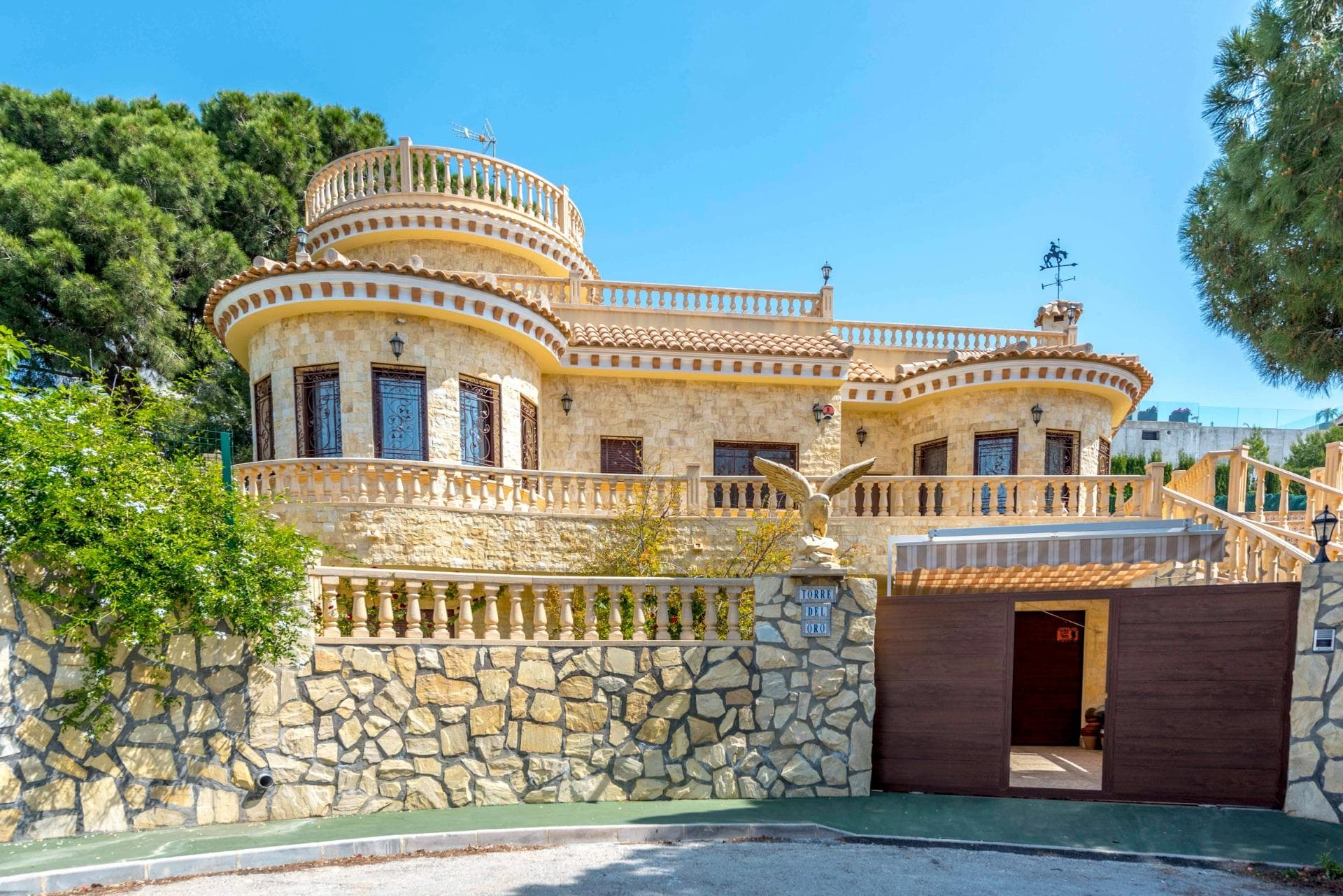 Mediterranean villa in Dehesa de Campoamor, 300 metres from the beach.. . 280 m2 of floor space. Private plot of 900 m2. 4 bedrooms. 3 bathrooms. Natural stone façade. Towers and terraces with balustrades. Security windows and doors. Artistic wrought-iron railings. Private infinity pool with mosaic tiles and waterfall. Garden with lawn and gazebo. Spacious covered areas. Photovoltaic solar panel installation. Private enclosed garage. Covered outdoor parking. Surrounded by mature trees. Close to golf courses, restaurants, supermarkets and La Zenia Boulevard
