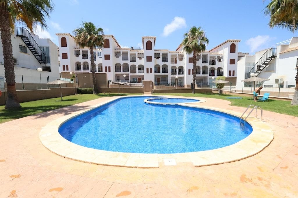 La Ciñuelica in Punta Prima. . South-facing 73 m2 duplex with 2 bedrooms, 1 bathroom, and 1 toilet. Features an independent kitchen with a back patio, and a living-dining room.. . The property boasts 2 terraces (one glazed), a 22 m2 solarium, and a 17 m2 tiled garden. Sold fully furnished with air conditioning and includes an underground parking space. Located in a residential complex with spacious green areas and a communal pool.
