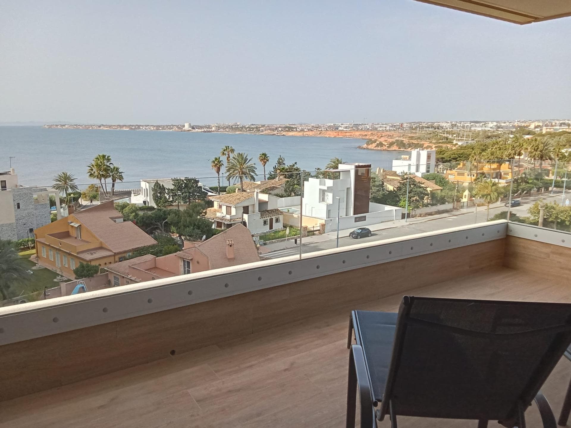 Apartment on the sixth floor, with elegant and modern design, like-new apartment, with frontal and panoramic sea views, on the sea front in Punta Prima! It consists of a living room with access to the spacious terrace (approximately 20 m2) with sea views, a separate fully equipped kitchen with a small pantry (for washing machine,…), two double bedrooms with built-in wardrobes, two bahtrooms and an underground parking space with a storage room in the same building. The main bedroom has an en suite bathroom and access to the terrace. Furnished. Ducted air conditioning and heating. Bathrooms with underfloor heating. Video intercom. South facing. Top-quality materials. Direct elevators access from the apartment to the parking and storage units. Concierge and video surveillance. Residential with 3 swimming pools (Infinity, heated and children’s pools) with sea views, outdoor jacuzzi, children’s play areas and gardens. Close to all amenities, cafes, supermarkets, … A luxury! With a privileged location a few steps from the sea facing the immensity Mediterranean sea!