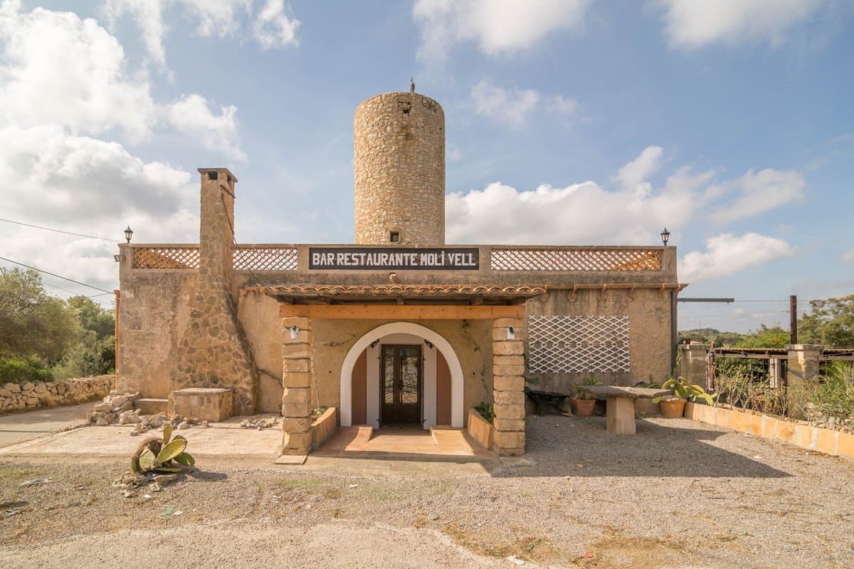 This charming commercial premises is strategically located on the edge of the road between Artà and Capdepera, in a picturesque rustic property near the Roca Viva golf course. The property stands out for its unique atmosphere, taking advantage of the structure of an old mill, and offers an ideal environment for a restaurant with charm and personality.Inside the restaurant we find an entrance and a hall with a welcoming access that welcomes customers. Large, spacious and bright dining room, with capacity for 32 people, designed to create a warm and pleasant atmosphere. Ideal for enjoying group meals or special events.Room with a bar counter with a functional and elegant area, perfect for serving clients and preparing drinks. The industrial kitchen fully furnished and equipped with modern appliances, this kitchen meets the highest standards of functionality and safety, making it easy to prepare a wide variety of dishes.Space for a changing room with a bathroom, designed for the comfort and privacy of the staff. A space designed for cleaning dishes and utensils, equipped with the necessary facilities to maintain hygiene and efficiency. It has two additional storage rooms, providing extra space for storage. The establishment has five bathrooms, distributed for the comfort of customers, including two bathrooms adapted for people with reduced mobility, guaranteeing accessibility for all.The exterior of the restaurant is adorned with several terraces, some covered, offering an ideal setting to enjoy al fresco dining and the surrounding landscape. A charming wood-burning oven and barbecue are available for lovers of outdoor cooking, adding a rustic and authentic touch to the menu. An outdoor bar that complements the restaurant's offering, ideal for serving drinks and cocktails while customers enjoy the natural environment.The property is sold fully equipped, ready to continue operating the restaurant without the need for additional investments. The activity license is up to date, guaranteeing legality and business continuity without setbacks.Some images have been generated using artificial intelligence to illustrate possible decoration options and showcase the property's potential.Important: Taxes, notary, and registration fees are not included in the sale price.As a construction company, we are happy to assist with any renovation, expansion, or building project you may have in mind.This establishment represents an exceptional opportunity for those seeking to establish or expand their business in a privileged location, with an infrastructure designed to offer a memorable dining experience. With its rustic charm and complete equipment, the restaurant is ready to welcome customers and become a benchmark in the area. Don't miss the opportunity to visit this property and discover its full potential!