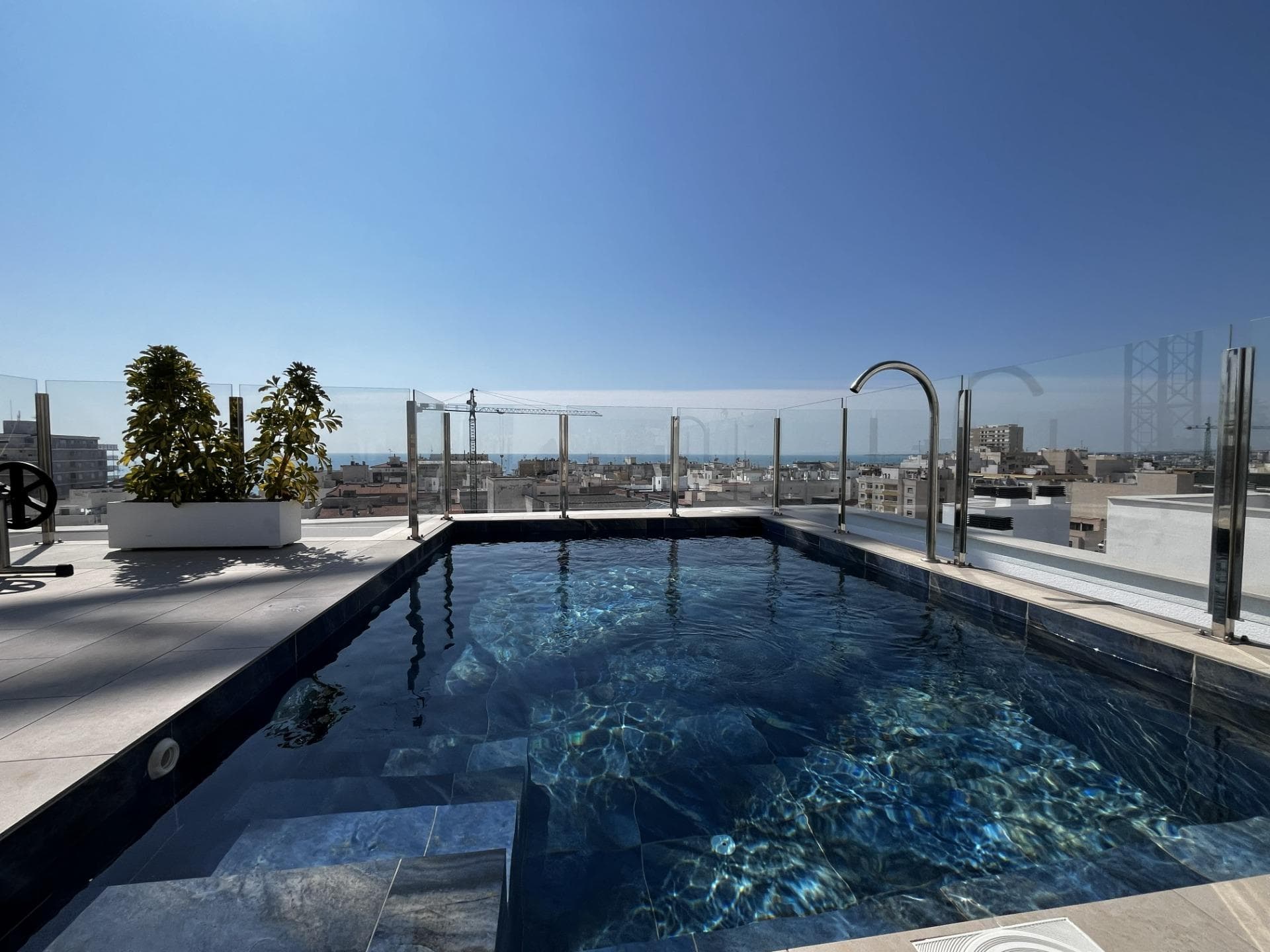 Modern resale apartment located on one of the main streets of Torrevieja, right in the city centre — just a 4-minute walk from the sea and Playa del Cura beach. This location guarantees everyday convenience and offers very high rental potential throughout the year. The property features a functional and spacious layout, consisting of two bedrooms and two modern bathrooms finished to a high standard. The interior has been designed in a practical and aesthetic way, using bright materials and contemporary solutions. A major advantage of the apartment is the large, well-lit built-in wardrobes, which provide excellent storage space and enhance everyday functionality. The entire property is maintained in a light, neutral colour palette, making the space feel even more open and inviting. The open-plan living area combines the kitchen and lounge with direct access to the balcony, creating a comfortable space for relaxation. Large windows ensure natural light throughout the day, significantly improving living comfort. The apartment is equipped with ducted air conditioning, providing even cooling and heating throughout the entire property — a much more comfortable and aesthetically pleasing solution compared to standard wall units. The property is sold fully furnished, including all furniture shown in the photos, allowing for immediate move-in or rental without additional investment. The building offers access to communal areas, including a swimming pool and a rooftop solarium with views of the Mediterranean Sea, further increasing the attractiveness of this property. The location is one of the key highlights — city centre, close to the sea, restaurants, shops and all essential services. It is an ideal property for rental investment due to the constant demand in this area of Torrevieja. This is an excellent opportunity for those looking for a ready-to-go investment in one of the most dynamic locations on the Costa Blanca. Contact us for more information or to arrange a viewing!