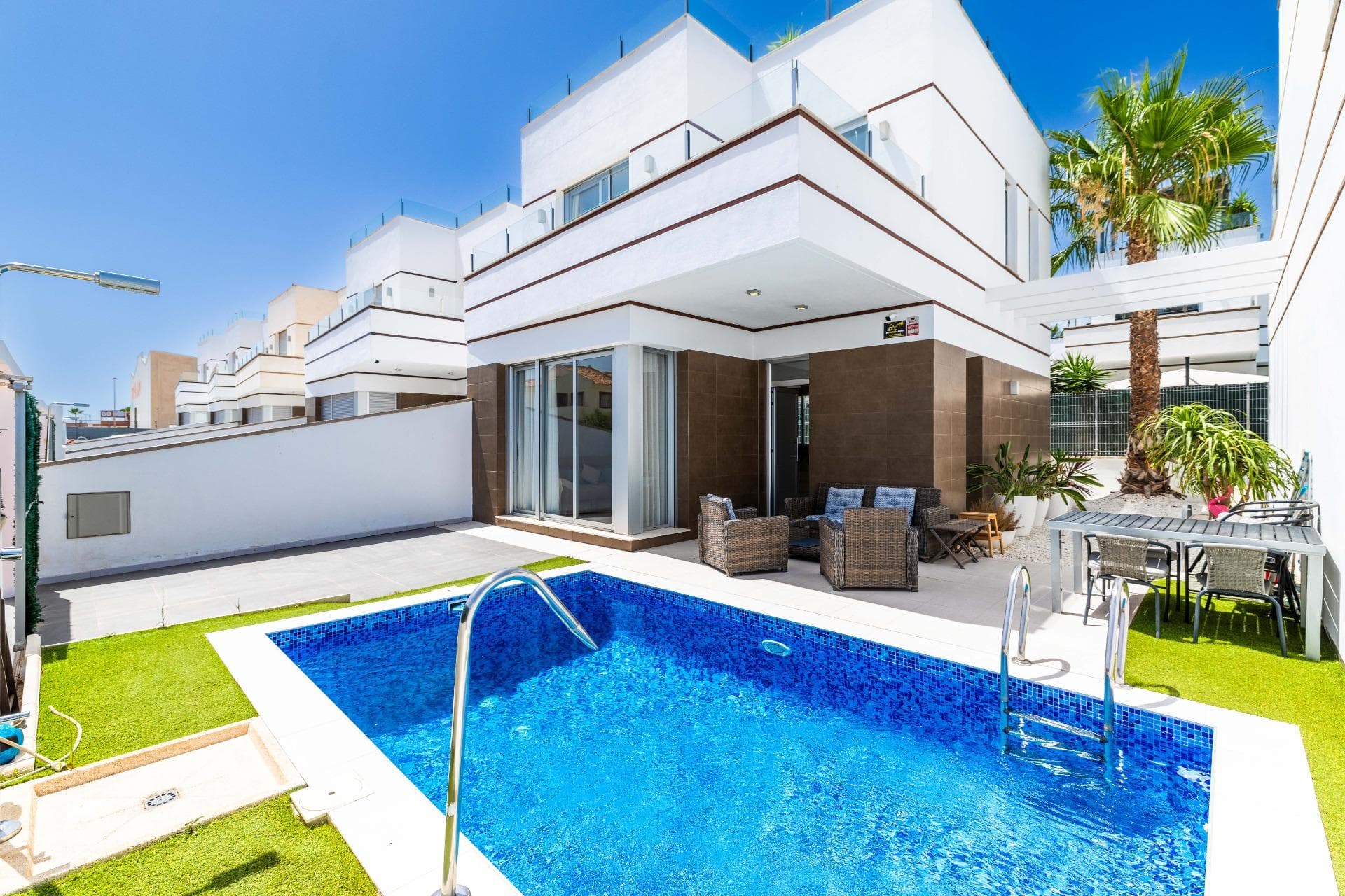 Luxury Villa with Private Pool in Doña Pepa – Ciudad Quesada Discover this elegant villa located in one of the most prestigious residential areas of Ciudad Quesada: Doña Pepa, an exclusive setting where tranquillity, comfort and the Mediterranean lifestyle come together in perfect harmony. Situated next to the renowned La Marquesa Golf & Country Club, the property enjoys a privileged location surrounded by wide avenues, green areas and beautiful views towards El Recorral Natural Park and the area's famous pink salt lakes. Doña Pepa offers an excellent quality of life thanks to its extensive range of amenities, including golf courses, a spa hotel, supermarkets, restaurants, cafés, medical centres, pharmacies, banks, sports facilities and a water park, all just a few minutes away. The villa offers 110 m² of built area and is ready to move into. Its southeast orientation ensures abundant natural light throughout the day, creating bright and welcoming living spaces. Upon entering the property, you are greeted by a spacious living and dining area with large windows that seamlessly connect the interior with the terrace and private swimming pool. The modern open-plan kitchen integrates perfectly with the living space, providing both functionality and comfort for everyday living and entertaining. The ground floor also features a bedroom with a built-in wardrobe and a fully equipped bathroom with a walk-in shower. Upstairs, there are two spacious bedrooms, both with en-suite bathrooms and direct access to a private terrace. One bathroom is fitted with a shower and the other with a bathtub, offering maximum comfort for residents and guests alike. The property is completed by a fantastic rooftop solarium of approximately 40 m², an ideal space to enjoy the Mediterranean climate all year round, relax outdoors or take in the surrounding views. Outside, the villa boasts a beautifully designed relaxation area, barbecue space, Mediterranean landscaping and palm trees that provide privacy and character. The private 3 x 5 metre swimming pool is the perfect place to enjoy sunny days in an exclusive and peaceful environment. With three bedrooms, three bathrooms, spacious terraces and an excellent location, this villa represents an outstanding opportunity as a permanent residence, holiday home or investment property in one of the most sought-after areas of the Costa Blanca. Contact us today to arrange a viewing and discover everything this exceptional property has to offer.
