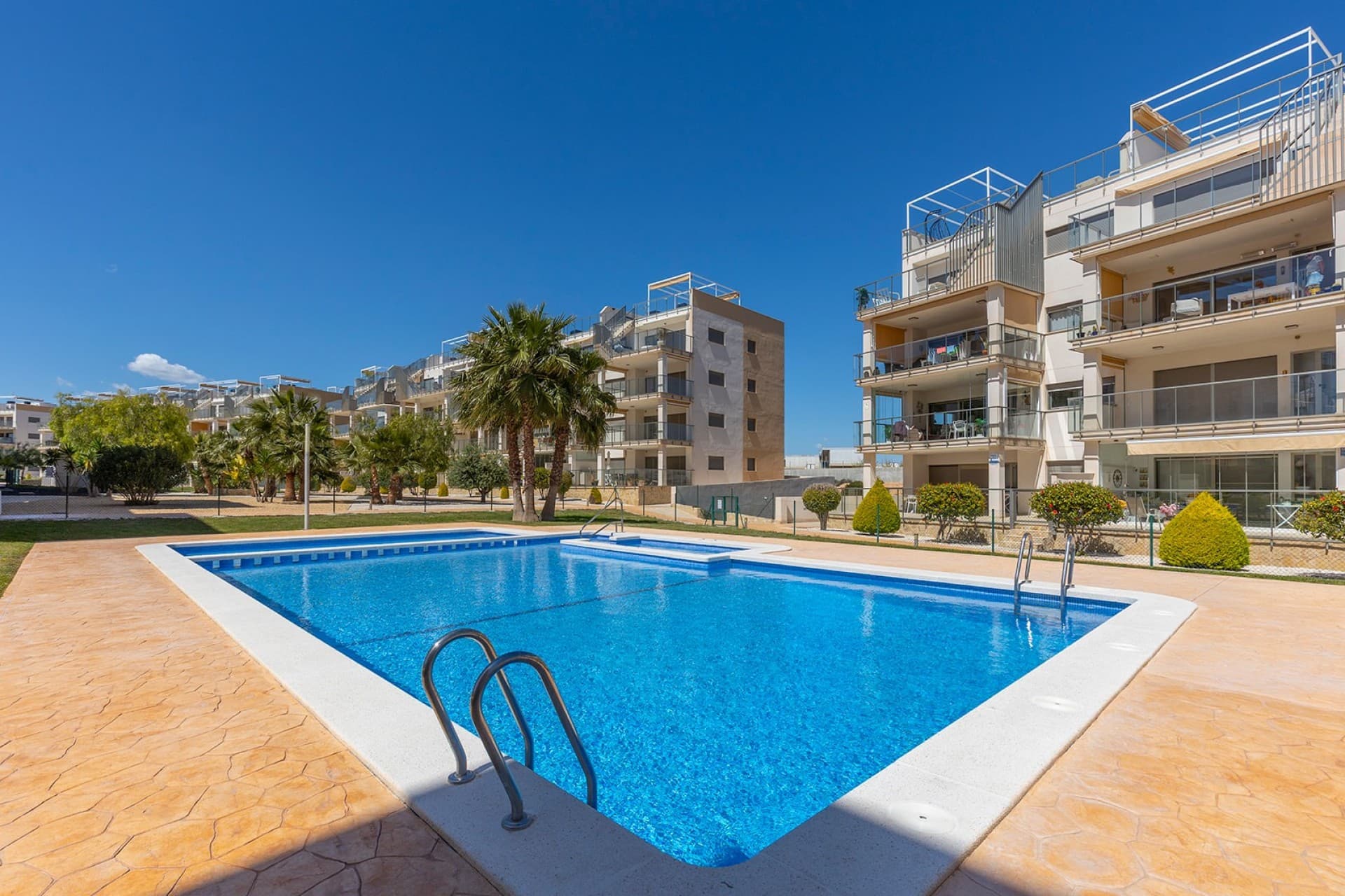 Discover this modern and elegant apartment, which is fully move-in ready, situated in the popular Villamartín neighbourhood. The apartment features 2 spacious bedrooms and 2 stylish bathrooms, one of which is en suite, finished to a high standard.The light-filled living room, together with the spacious, modern open-plan kitchen, creates the perfect setting for comfortable and contemporary living. Both the living room and the kitchen, which has a separate utility room, offer direct access to a spacious terrace, ideal for enjoying the Mediterranean climate all year round. Thanks to its excellent south-facing orientation, the property enjoys natural light throughout the day. In addition, the apartment features an underground parking space and a storage room, providing extra comfort and functionality. Located in an exclusive and quiet residential complex, you can enjoy three communal swimming pools, one of which is indoor and heated, as well as spacious, meticulously maintained gardens with palm trees and Mediterranean vegetation that create an idyllic atmosphere. Furthermore, there are petanque courts, fitness equipment and a children’s playground. Villamartín is renowned for its prestigious 18-hole golf course and its characteristic Plaza, offering a wide range of charming restaurants and bars. Just a few minutes away are supermarkets, shops and the popular open-air shopping centre La Zenia Boulevard, putting all amenities within easy reach. Furthermore, the beautiful beach of La Zenia is just 2.6 km away, ideal for those who want to enjoy the sun, sea and sand. The location is therefore excellent, and Alicante and Murcia airports are approximately 50 and 40 minutes’ drive away respectively, ensuring excellent accessibility. A unique opportunity, perfect as a holiday home, permanent residence or investment on the Costa Blanca.