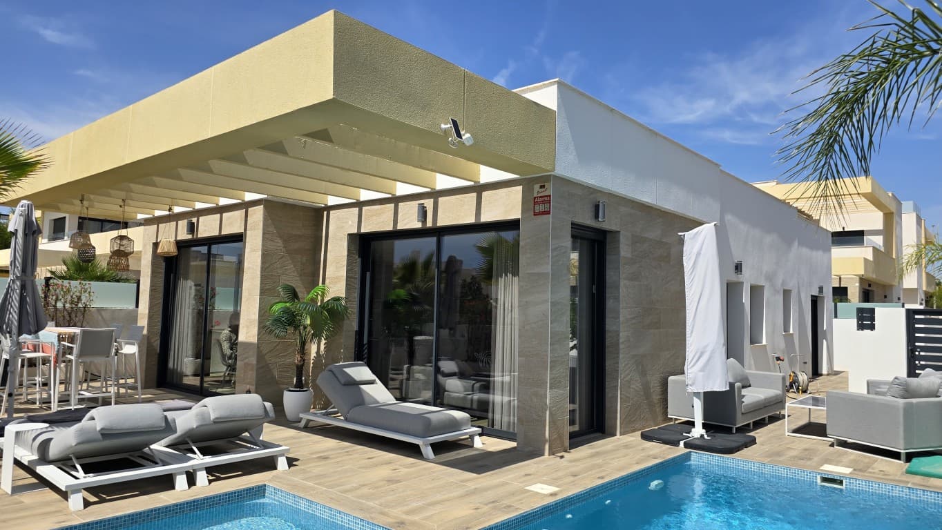 single-story corner villa with 3 bedrooms. Are you looking for a recently built, move-in ready home on the Costa Blanca&8364; This modern single-story corner villa, completed in 2022 and located in the popular residential area of La Herrada in Los Montesinos, offers luxury, comfort, and energy efficiency. Just 10 minutes from the beaches of Guardamar and Torrevieja.As part of a prestigious development, built by a renowned developer with over 40 years of experience, this villa features 3 bedrooms, 2 bathrooms, a sunny terrace, and a private pool. Thanks to the corner lot, you’ll enjoy extra natural light, more privacy, and a more spacious garden layout.High-quality finishes and thoughtful designThis home was built to the latest construction standards and includes:* Reinforced concrete structure* Double-insulated exterior walls with air cavity* Dark-colored aluminum windows with double glazing and sunshades* Electric roller shutters in the bedrooms, built-in floor-to-ceiling wardrobes with wood interior finish* Underfloor heating in the bathrooms with digital thermostat* Fully integrated air conditioning systemThe kitchen features a Silestone countertop, an integrated undermount sink, and a built-in wine cooler. The bathrooms are equipped with elegant white fixtures, a walk-in shower with a glass wall, and heated floors for added comfort.Enjoy the Mediterranean lifestyle on your south-facing terrace, in the private pool, with unobstructed views of the surroundings. The low-maintenance garden features artificial grass and is fully fenced for maximum privacy.The location is unbeatable:* Just a 4-minute walk to the supermarket, restaurants, and pharmacy* 10 km from the beaches of Guardamar and Torrevieja* 6 km from the La Marquesa golf course* 40 km from Alicante International AirportLos Montesinos is surrounded by nature reserves, salt lakes, and bike paths, ideal for those who love hiking, birdwatching, and a peaceful outdoor lifestyle
