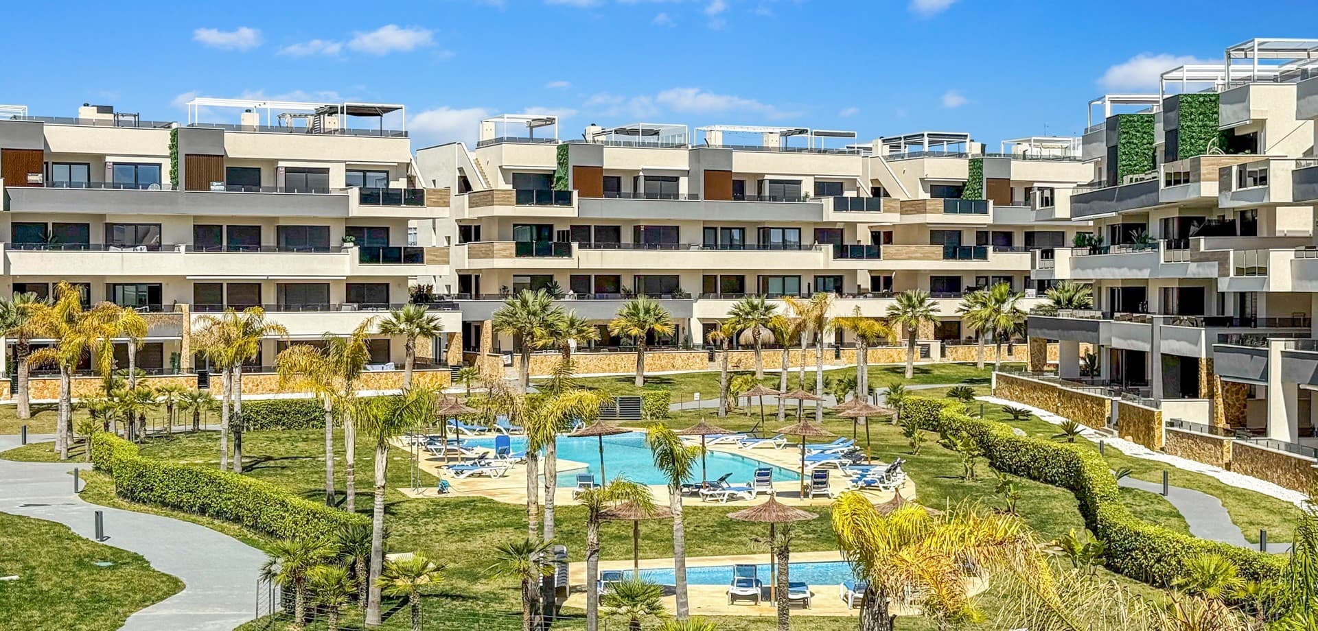 Step into refined coastal living with this exceptional 3-bedroom, 2-bathroom apartment, ideally located just moments from the sea and within walking distance of vibrant bars, restaurants, shops, and supermarkets. Whether you're searching for a stylish holiday escape, a premium rental investment, or a full-time residence by the Mediterranean, this property offers the perfect balance of lifestyle and location.Designed for seamless indoor-outdoor living, the apartment boasts a spacious wraparound terrace with direct access from all three bedrooms—offering breathtaking panoramic sea views. The master bedroom features a modern en-suite bathroom, while the two additional bedrooms provide generous space for family or guests, complemented by a second fully equipped bathroom.The property is beautifully presented and sold fully furnished with high-end designer furniture and elegant finishes throughout, making it completely move-in ready. Additional features include ducted air conditioning, electric shutters, underfloor heating in the bathrooms, and a private double parking space with a large storage room.Set within a secure gated community, residents enjoy access to a large swimming pool surrounded by landscaped gardens with ambient evening lighting, as well as premium wellness facilities including a fully equipped gym, sauna, Jacuzzi, and changing areas.This is a rare opportunity to own a turnkey luxury apartment in a prime coastal location—where comfort, style, and convenience come together effortlessly.