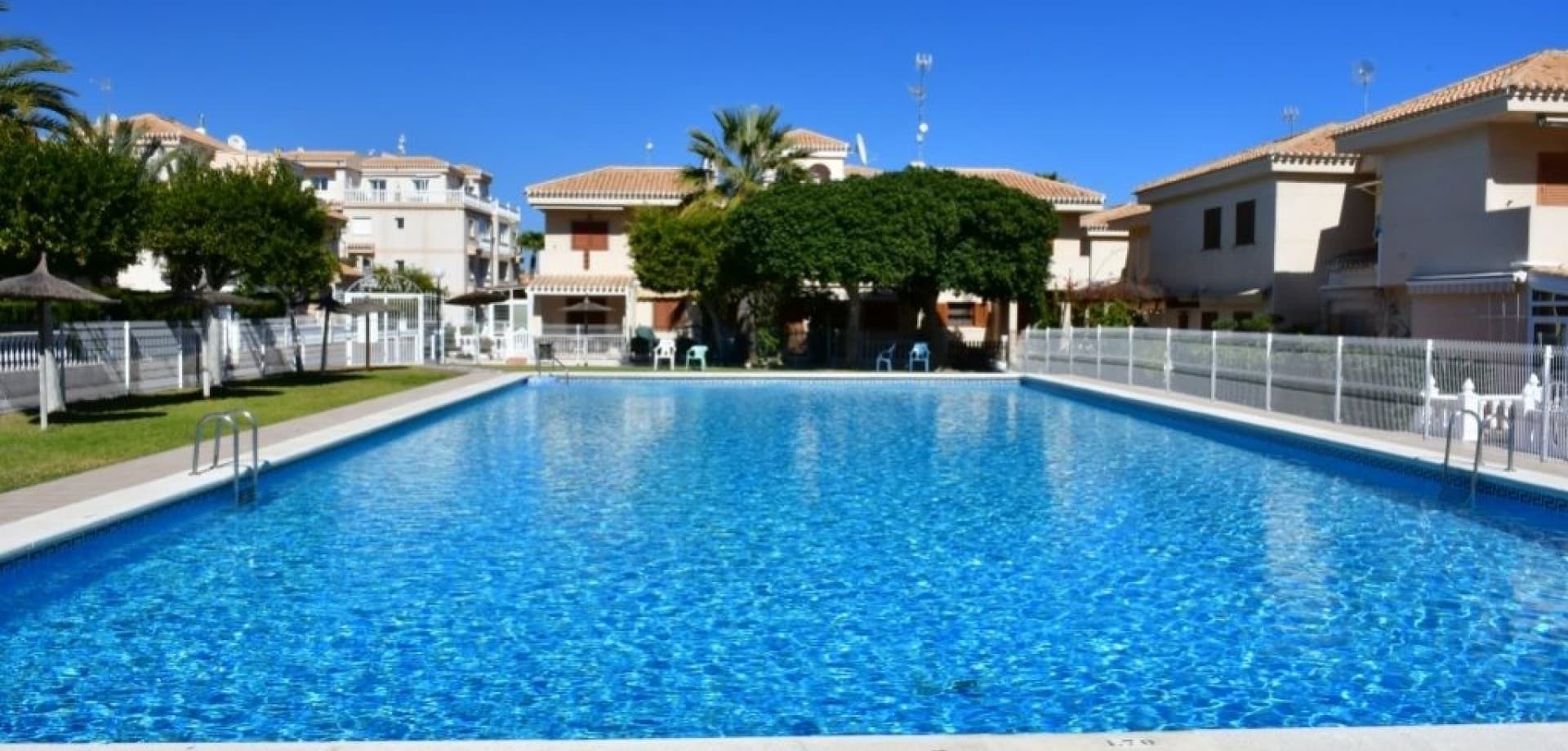 Located in the highly sought-after area of Playa Flamenca, this charming ground floor apartment offers a perfect combination of comfort, outdoor living, and investment potential on the Costa Blanca.Set within a well-maintained gated community with beautifully landscaped gardens and a communal swimming pool, the property enjoys a peaceful yet central location, just minutes from all amenities and the renowned La Zenia Boulevard.The apartment offers approximately 65 m² of living space and features a spacious private outdoor patio — ideal for dining, relaxing, and enjoying the Mediterranean climate all year round.Inside, the layout includes a bright living and dining area with air conditioning, a fully equipped kitchen with a practical breakfast bar, two bedrooms, one full bathroom, and a convenient storage room.The property is in good condition and ready to move into, making it an excellent choice as a holiday home, permanent residence, or a high-performing rental investment thanks to strong demand in the area.