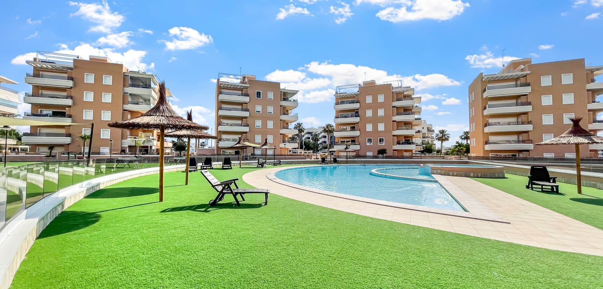 Located in the highly desirable residential area of El Raso, near Guardamar del Segura, this stunning modern apartment offers the perfect combination of contemporary design, comfort, and convenience. Situated within a secure gated community completed less than a year ago, the property enjoys access to beautifully landscaped communal gardens, a large swimming pool, and private underground parking.Positioned on the first floor and benefiting from a privileged corner location within the building, the apartment enjoys additional privacy and an abundance of natural light throughout the day.The spacious open-plan living and dining area flows seamlessly into the contemporary fully equipped kitchen. Large sliding doors connect the interior with a generous private terrace overlooking the attractive communal gardens, creating the perfect space for outdoor dining and relaxation.The property features three bedrooms and two modern bathrooms, including a stylish master suite with its own en-suite bathroom. The apartment is sold partially furnished, allowing the new owners to personalise the home to their own taste.Residents benefit from lift access, secure underground parking, beautifully maintained gardens, a large communal swimming pool, a wellness area with spa and sauna facilities, and a dedicated petanque court.El Raso has become one of the most sought-after locations on the Costa Blanca thanks to its peaceful surroundings, modern developments, and close proximity to the beaches of Guardamar del Segura. Restaurants, cafés, supermarkets, and all essential amenities are within easy reach.