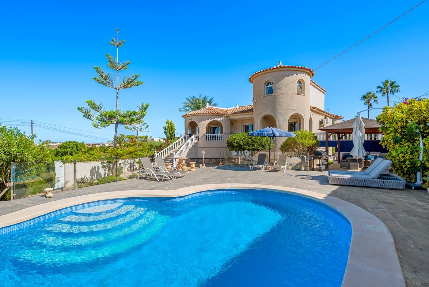 Enjoy endless sunny days in this magnificent Spanish-style villa, perfectly located in Urb. Lomas De La Juliana, Almoradí, just minutes from the prestigious La Finca Golf Resort.This impressive 5-bedroom villa offers abundant space for family living and entertaining guests, all in a setting that guarantees privacy and tranquility.The main house features 3 spacious bedrooms with built-in wardrobes, a fully equipped kitchen, and a generous living room with a beautiful working fireplace and a bright dining area.With a private entrance, the underbuild apartment provides 2 additional bedrooms, a large living room, and a fully equipped kitchen with ample storage, perfect for hosting guests while ensuring their privacy.Offering the perfect spot to relax and enjoy yourself after dinner, the garage has been converted into a fun playroom, while a stylish wooden carport comfortably accommodates two cars.The villa is surrounded by a large, low-maintenance garden, complete with its own putting green to practice your golfing skills.South-facing and free from direct neighbors, the property offers privacy and stunning views. The spacious terrace is the perfect spot to relax and enjoy spectacular sunsets and lemon tree fields, while the 8x4m swimming pool invites you to cool off on warm days.Just minutes from the Mediterranean, La Finca Golf is one of the Costa Blanca’s most prestigious resorts. With its championship 18-hole course, luxury hotel, spa, fine dining, and vibrant community, it offers the perfect blend of leisure and elegance. This is a rare opportunity,don’t miss your chance! Book a visit today and experience this exceptional home for yourself.