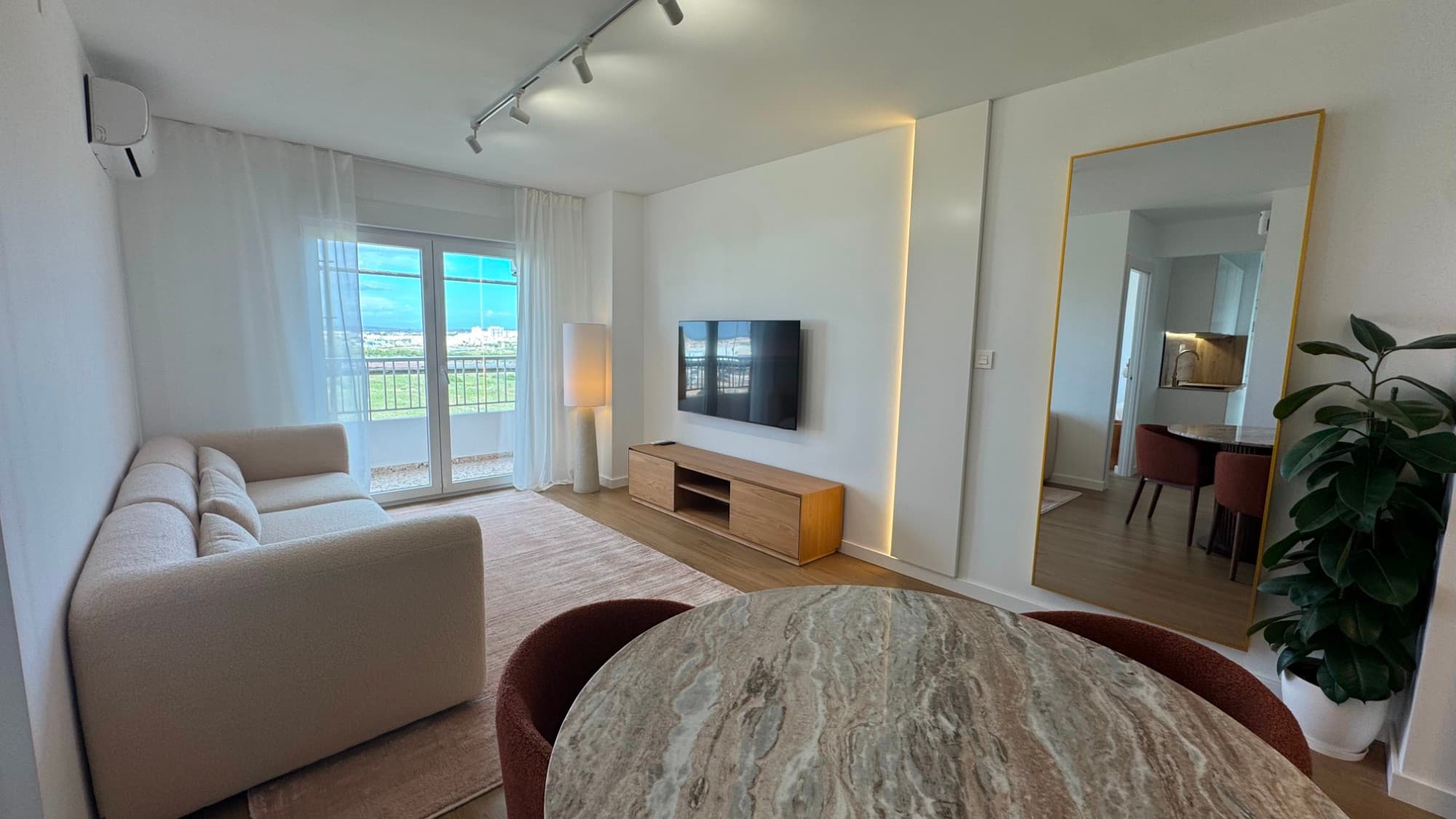 This fully renovated corner penthouse in Punta Prima offers a rare combination of panoramic views, privacy, and modern comfort, just 500 meters from the Mediterranean Sea. Located on the 6th floor, the property enjoys an elevated position with open views from the sea and the city skyline.The apartment has been completely refurbished with a clear focus on quality, light, and space. Thanks to its corner position and unique layout, all rooms open directly onto the terrace, eliminating internal patios and allowing natural light to flow throughout the entire home. The result is a bright and airy living environment that feels both open and private at the same time.Inside, the property offers two bedrooms and one bathroom, all finished in a modern style with carefully selected materials such as large-format porcelain tiles and natural stone details. The apartment is sold fully furnished with designer furniture and is equipped with a modern kitchen, induction hob, inverter air conditioning with WiFi control, a programmable boiler, and a full security system. High-quality sound-insulated panoramic windows further enhance the comfort, making the home peaceful despite its central location.The building offers lift access, a communal swimming pool, and gated communal parking with covered spaces. In addition, a full façade renovation is currently underway and already fully paid, which adds long-term value without any additional cost for the new owner.One of the standout features of this property is that it already holds a tourist rental license, which can be reissued to the new owner. Combined with its location in a high-demand area close to the sea, this makes it an excellent option both as a private residence and as an investment.Corner penthouses with these kinds of views are rarely available in this price range and are more commonly found in significantly higher-end properties. This is a unique opportunity to acquire something truly special in Punta Prima.