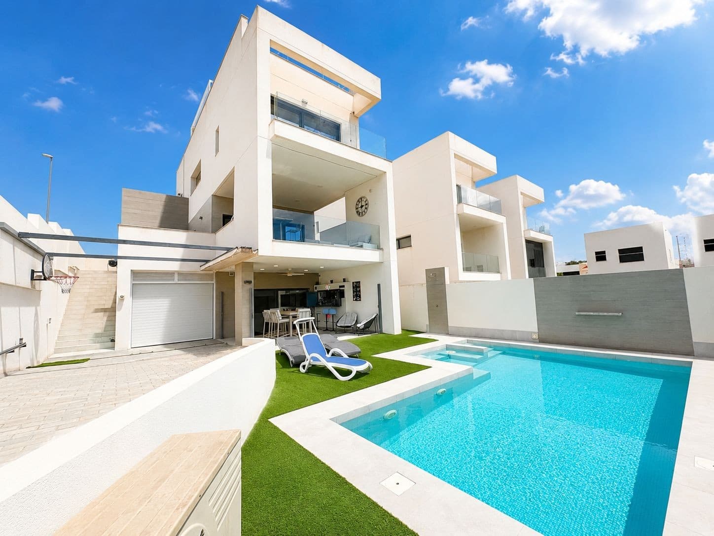 Today we are delighted to present this exceptional 4-bedroom, 4-bathroom detached villa located in the highly sought-after area of Benijófar. Set on a generous 400m² plot with an impressive 310m² of living space, this immaculate modern home offers luxury living at its finest.From the moment you arrive, this property immediately impresses with its elevated position, providing breathtaking uninterrupted mountain views and complete privacy throughout.As you enter the villa, you are welcomed into a bright and airy open-plan living space featuring soaring high ceilings, stunning contemporary artwork, and large floor-to-ceiling windows that flood the home with natural light. Every inch of this home has been finished to an exceptional standard, creating a truly luxurious atmosphere.On the entrance level, you will find a beautifully tiled guest washroom, additional storage space, and a spacious main bedroom complete with fitted wardrobes, a stylish private en-suite bathroom with walk-in shower, and patio doors leading directly onto one of the sun-drenched terraces.The elegant dining area flows seamlessly through the property, surrounded by large windows that enhance the sense of space and light throughout the home.On the lower level, the villa continues to impress with a spectacular designer kitchen featuring a large breakfast bar seating at least six guests, integrated oven and hob, American-style fridge freezer, and extensive workspace. Large sliding patio doors open directly onto the outdoor entertaining and pool area, creating the perfect indoor-outdoor lifestyle.Also on this floor is another generously sized double bedroom with extensive wardrobe space and a luxurious bathroom with a walk-in shower. Cleverly hidden within this level is a secret door leading to the garage, gym area, and additional storage space — a unique and stylish touch that perfectly complements the modern design of the home.Outside, the villa truly comes to life. The private swimming pool is surrounded by multiple seating and relaxation areas, ideal for entertaining family and friends. One of the standout features of this property is the incredible fully stocked outdoor bar area — affectionately known as “Gin Paradise” — an absolutely spectacular entertainment space that must be seen to be appreciated.Ascending the beautifully designed wooden staircase to the top floor, you are greeted by an incredible landing area leading to the magnificent master suite. This stunning bedroom features large sliding patio doors opening onto a private terrace where you can wake up every morning to breath taking panoramic mountain views and views to the beautiful Pink Salt lakes , The master suite also benefits from a luxurious private en-suite bathroom with walk-in shower.A further spacious double bedroom with its own en-suite bathroom completes this level, offering comfort and privacy for guests or family members.At the top of the property, you will find an enormous private rooftop solarium finished with artificial grass and offering some of the most spectacular views in the area. Thanks to the villa’s elevated position, the scenery remains completely unspoiled, creating a peaceful and luxurious setting perfect for relaxing or entertaining.This home is truly a dream property — combining modern luxury, incredible architecture, spacious living, outstanding outdoor areas, and unforgettable views. Every detail has been carefully designed and finished to the very highest standard.A must-see villa in one of the Costa Blanca’s most desirable locations.