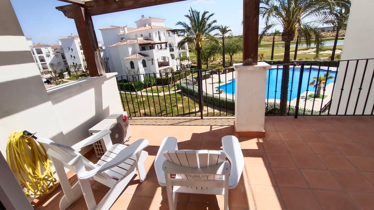 This light, bright and exceptionally spacious apartment on Calle Adriático truly has it all — spectacular golf and lake views, dual terraces, lift access, underground parking, and an enviable position just 200 metres to the town centre restaurant and supermarket.The apartment opens into a generous living–dining area featuring an attractive curved wall design that creates a defined dining space. The room is furnished with a glass dining table and chairs, comfortable sofa, auxiliary seating, and storage units, offering a welcoming and practical layout.Large patio doors lead directly onto the spacious east-facing terrace, where you can enjoy spectacular open views across the swimming pool, golf course and lake. Perfect for morning coffee and sunrise views, this terrace benefits from one of the resort’s most sought-after orientations while remaining conveniently close to the bar and amenities.To the left of the entrance hallway is the impressively large, square kitchen — fully fitted with ample cabinetry and complete with fridge-freezer, washing machine, dishwasher, ceramic hob, oven and extractor fan. A kitchen window frames beautiful golf course views, making it both bright and enjoyable to work in.The curved wall in the living room leads through to an inner hallway giving access to the sleeping accommodation.On the left is a spacious family bathroom, fitted with shower, WC and vanity unit.There are two bedrooms:Master bedroom with double bed, fitted wardrobes, bedside cabinets and air conditioningSecond bedroom currently arranged with a single sofa bed and air conditioningBoth bedrooms benefit from patio doors opening onto a second west-facing terrace, enjoying mountain views and evening sunshine — ideal for relaxing at the end of the day. With doors open to both east and west terraces, the apartment benefits from excellent natural airflow and a wonderful cross-breeze.The property is sold fully furnished as seen and is located in a prestigious building with lift access. An underground parking space is included in the sale.Set within the beautiful Hacienda Riquelme Golf Resort, residents enjoy:19 communal swimming poolsLandscaped gardens24-hour securityGolf course and driving rangeSports facilitiesOn-site supermarket and restaurantThe charming village of Sucina is just a short drive away, with the coast and airport approximately 20 minutes by car.This is an ideal lock-up-and-leave holiday home, yet spacious enough for comfortable permanent living. Early viewing is highly recommended.