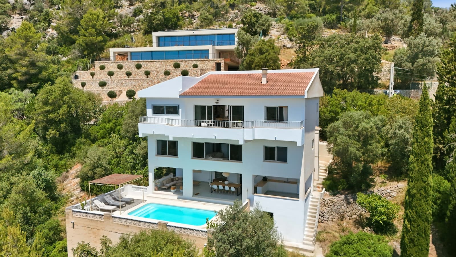 Villa with Spectacular Views over the Bay of Palma in Sought-After Sa Font SecaNestled in the highly desirable area of Sa Font Seca, between Palma de Mallorca and Bunyola, near Palmanyola and at the foothills of the Serra de Tramuntana, this unique villa offers a rare combination of privacy, panoramic views and exceptional potential. The location provides the perfect balance between peaceful natural surroundings and easy access to city life, with Palma city centre just 10–15 minutes away and the airport approximately 20 minutes by car.The area has become increasingly sought-after in recent years, attracting buyers looking for exclusive surroundings within easy reach of Palma. Several neighbouring luxury villas and newly built properties have been sold for multi-million-euro prices, highlighting both the prestige of the area and its long-term investment potential.The property is distributed across three levels and offers a total of 5 bedrooms and 2 bathrooms.The upper floor, which also serves as the main entrance level, has already been modernised with new flooring and a beautifully renovated bathroom. The existing kitchen remains in place, while the layout has been opened up to allow the new owner to create a stunning open-plan kitchen and living area according to their own taste and requirements. This level also includes 2 bedrooms, one of which is currently used as a DJ studio but could easily serve as an additional bedroom, guest room or home office. The breathtaking views can be enjoyed from the living areas, kitchen, bedrooms and terraces, creating an incredible sense of space, light and freedom throughout the home.The middle floor currently comprises 3 bedrooms, 1 bathroom and an impressive double living room. Part of the living area is presently used as an office, but there is excellent potential to create a luxurious master suite complete with an en-suite bathroom and walk-in wardrobe. This level also benefits from a dedicated laundry room and a walk-in dressing room. The generous layout provides endless possibilities for creating a contemporary family home tailored to modern living. The staircase and this floor offer the opportunity for the new owner to add their own personal touch and further enhance the property's value.The lower level opens directly onto a truly stunning outdoor living space with authentic Ibiza-style charm. Here you will find a large covered lounge area, a spacious outdoor kitchen designed for long Mediterranean evenings with family and friends, and a beautiful swimming pool surrounded by terraces and lush greenery. The gardens and outdoor spaces offer an exceptional degree of privacy, allowing you to fully embrace Mallorca's relaxed lifestyle in complete tranquillity.The views over the Bay of Palma are simply spectacular. During the day, the eye is drawn across the beautiful landscape, the surrounding greenery and all the way to the sea. As evening falls, the scenery becomes even more magical as the lights of Palma and the surrounding luxury residential areas begin to sparkle across the horizon. It is the kind of view that never loses its appeal.This is a property for buyers looking to create their dream home in one of Mallorca's most exciting and increasingly desirable residential areas. Combining an exceptional location, generous living space, outstanding views, privacy and tremendous potential, this villa represents a unique opportunity as a permanent residence, holiday home or long-term investment.