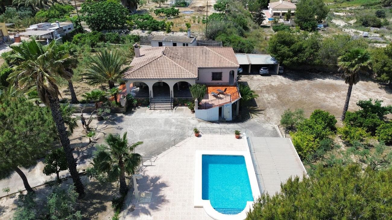 Stunning 5-bedroom villa in El Rebolledo – A true hidden gem with enormous potentialThis magnificent villa in El Rebolledo offers an exceptional opportunity – ideal as a family home, holiday home or as a profitable investment on the sunny Spanish Costa Blanca. Layout & featuresLiving area: 130 m² Bedrooms: 5 (spread across two sections, each with its own bathroom, ideal for hosting guests) Bathrooms: 2 Kitchen: fully equipped Connected to mains water and electricity Your own wine cellar Outdoor living & extrasPrivate swimming pool Huge garage Carport for 4 cars + large open space with great potential 2,600 m² plot, fully maintained and in excellent condition Numerous olive and citrus trees Spacious terraces and outdoor areas to enjoy the Mediterranean lifestyle Separate outbuilding with kitchen, storage space and bathroom/laundry room LocationJust a 10-minute drive to the centre of Alicante, with the beach, shops, bars and all amenities 15 minutes to Elche–Alicante Airport Excellent connections to Alicante and Murcia A unique opportunityThis exclusive villa combines space, tranquillity and elegance in a prime location.Perfect for anyone looking for a comfortable family home, a sunny second home or a property with excellent rental potential. 