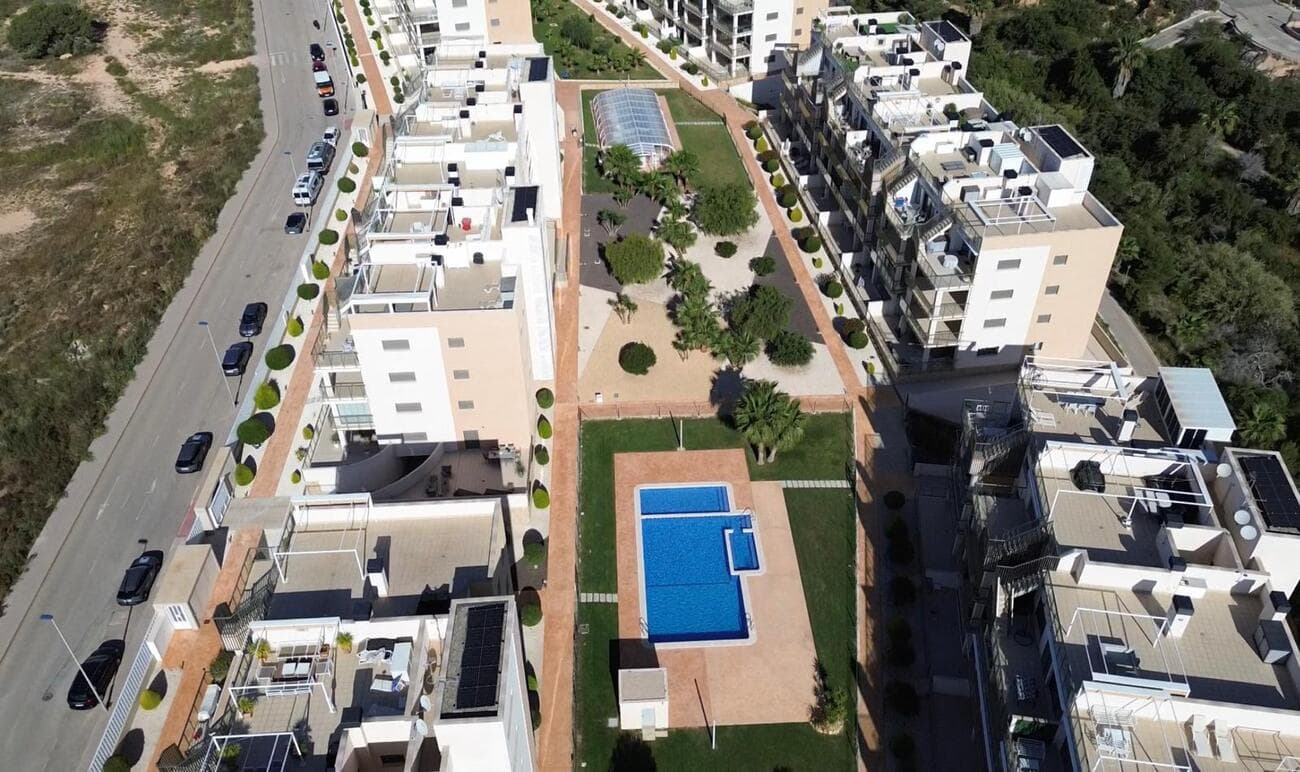 This is a fantastic opportunity to purchase a spacious ground-floor flat that has just come onto the market. Located in a residential area of Villamartín, on the Southern Costa Blanca, this beautiful flat offers the following features:   Three bedrooms and two bathrooms!   Built area of approximately 85 m²   South-facing terrace of 53 m²   Private parking space and storage room   2 electric bikes included   3 large communal swimming pools, one of which is heated   5 minutes from La Zenia shopping centre and 10 minutes from the sea   Here is an overview of this fantastic flat. Upon entering, you’ll find a spacious open-plan area with a beautiful kitchen, dining area and living room. With three spacious bedrooms featuring fitted wardrobes and two well-equipped bathrooms, this flat offers a lovely home for anyone looking for a flat in an excellent location. You can enjoy the sun all day long on the south-facing terrace, which is partially covered to provide plenty of shade in summer.   The terrace leads to the three large communal swimming pools. One of the pools is heated, so you can enjoy swimming all year round!  This is a fantastic opportunity to purchase a very spacious flat at an excellent price, situated within walking distance of La Zenia shopping centre and the beach, as well as a selection of local restaurants, shops and bars, and just a short drive from several golf courses.   Please contact us to arrange a viewing today.     