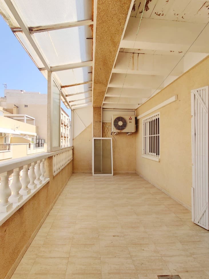 Penthouse apartment for renovation in a prime location in Torrevieja, just next to Avenida de la Purísima and only a one-minute walk from the seaside promenade. The property is perfectly situated within walking distance to both Playa del Cura (4 minutes) and Playa de los Locos (7 minutes), surrounded by cafes, restaurants, supermarkets, and all essential amenities, as well as close to the city center.Located on the third (top) floor with elevator access, the apartment offers 75 m² of interior space plus a spacious 20 m² north-facing terrace with great potential. The layout includes a bright living room with an open-plan kitchen, three bedrooms, two bathrooms, and a hallway. The property requires a full renovation, making it an excellent opportunity to create a modern home or investment in one of the most desirable coastal areas. The building is well-maintained and features a communal swimming pool, and once renovated, this penthouse can become a truly attractive property, especially thanks to its large terrace and unbeatable location near the sea.
