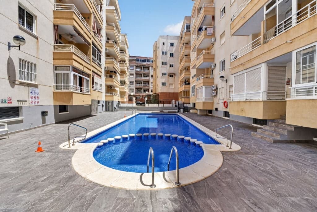 Torrevieja Town Centre – Spacious and bright apartment with 3 bedrooms and communal poolWelcome to a spacious and inviting apartment with a central location in Torrevieja!<br />Here you live only approx. 750 metres from the beautiful promenade and the Mediterranean Sea – with everything you need right on your doorstep.LocationThe apartment is located in a well-established area in the heart of Torrevieja that is lively all year round.Within walking distance you will find:The promenade and the beach Restaurants, bars, and cosy cafés Shops and local services Supermarkets and town centre amenities The area is perfect both for holidaymakers and permanent residents who want to enjoy the Spanish lifestyle close to the sea.Here you will enjoy a comfortable and central location with an authentic Spanish atmosphere and all amenities nearby.The PropertyThe apartment has a built area of approx. 82.66 m² and feels bright and welcoming.The property includes:3 bedrooms 2 bathrooms Bright living room with dining area Kitchen with plenty of storage space and white goods 1 bathroom with shower 1 bathroom with bathtub Patio/storage area Lovely corner terrace with open views The apartment has air conditioning and is sold partly furnished with white goods included.Communal AreasPleasant urbanisation with:Beautiful communal pool area Palm trees Communal rooftop terrace Lift in the building Key FeaturesApartment Built area: approx. 82.66 m² 3 bedrooms 2 bathrooms Terrace Communal rooftop terrace Air conditioning Lift Communal swimming pool Partly furnished White goods included Energy rating: E Year built: 2001 Financial InformationPrice: €159,000 + costsProperty tax (IBI): approx. €250 per year<br />Waste collection tax: approx. €80 per yearWhen purchasing a resale property in this region, you should expect approx. 10% transfer tax (ITP) of the purchase price (from June 1st: 9%).In addition, the following costs apply:Notary fees Land registry fees New utility contracts (water and electricity) Administrative costs These are typically estimated at approx. €2,000 – €4,000.SummaryA spacious and centrally located apartment with 3 bedrooms, terrace, and communal pool – just a short walk from the promenade and the Mediterranean Sea.Perfect for anyone looking to live centrally in Torrevieja with everything within easy reach.Contact us for a viewing or more information! 