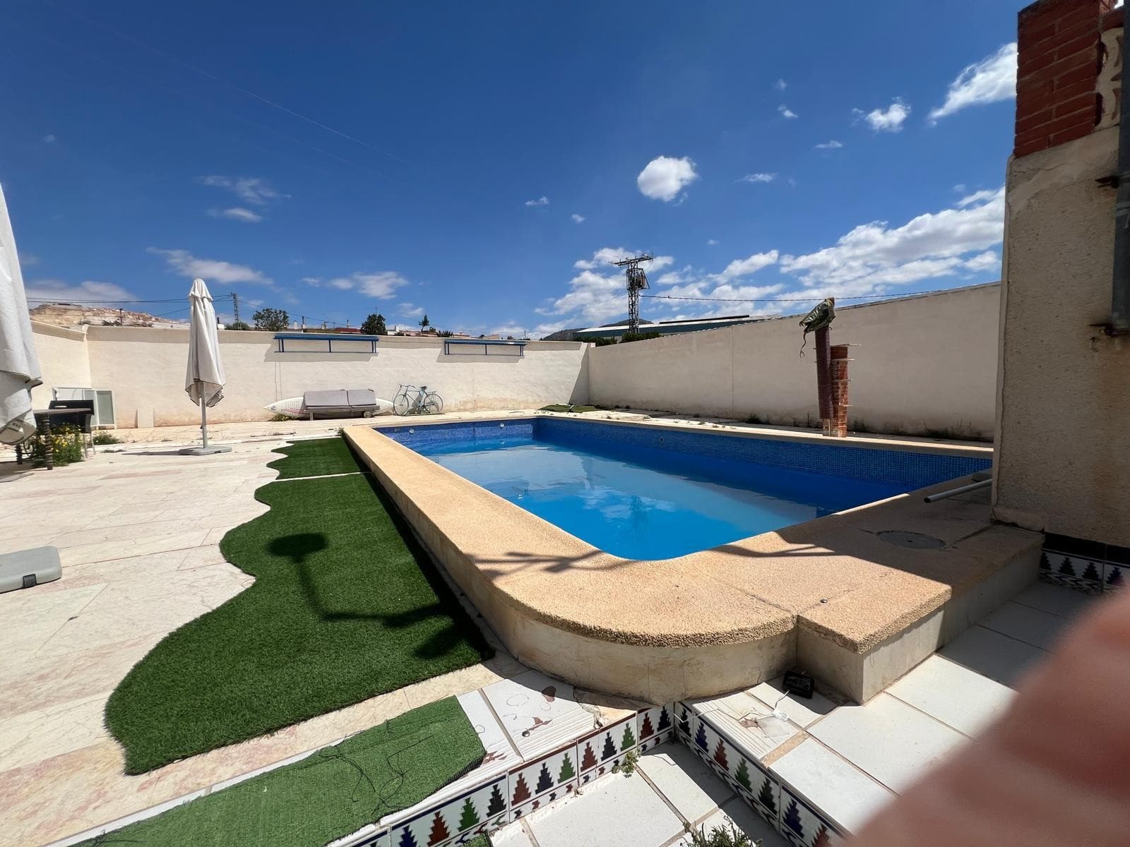Discover this delightful single-storey home set on a spacious, fully fenced plot in a peaceful area of Algueña. With a secure gated entrance and plenty of outdoor space, this property offers the perfect balance of privacy, comfort, and rustic charm.The house features a generous front porch, ideal for relaxing outdoors, two inviting living rooms each with its own fireplace (one with wood paneling for a warm, cabin-like feel), a fully equipped independent kitchen, two bright and comfortable bedrooms, and a well-maintained full bathroom.A highlight of this property is its private sauna, offering a wellness experience right at home. The plot also includes several outbuildings, including a dedicated animal shelter, ideal for keeping poultry, small livestock or pets. There are also paved outdoor areas suitable for parking, gardening, or entertaining.This property is perfect as a main residence, weekend getaway, or investment opportunity with great potential —All in a quiet yet well-connected location within the village, offering both privacy and convenient access to nearby services-Book your visit today and fall in love with the lifestyle this property has to offer.