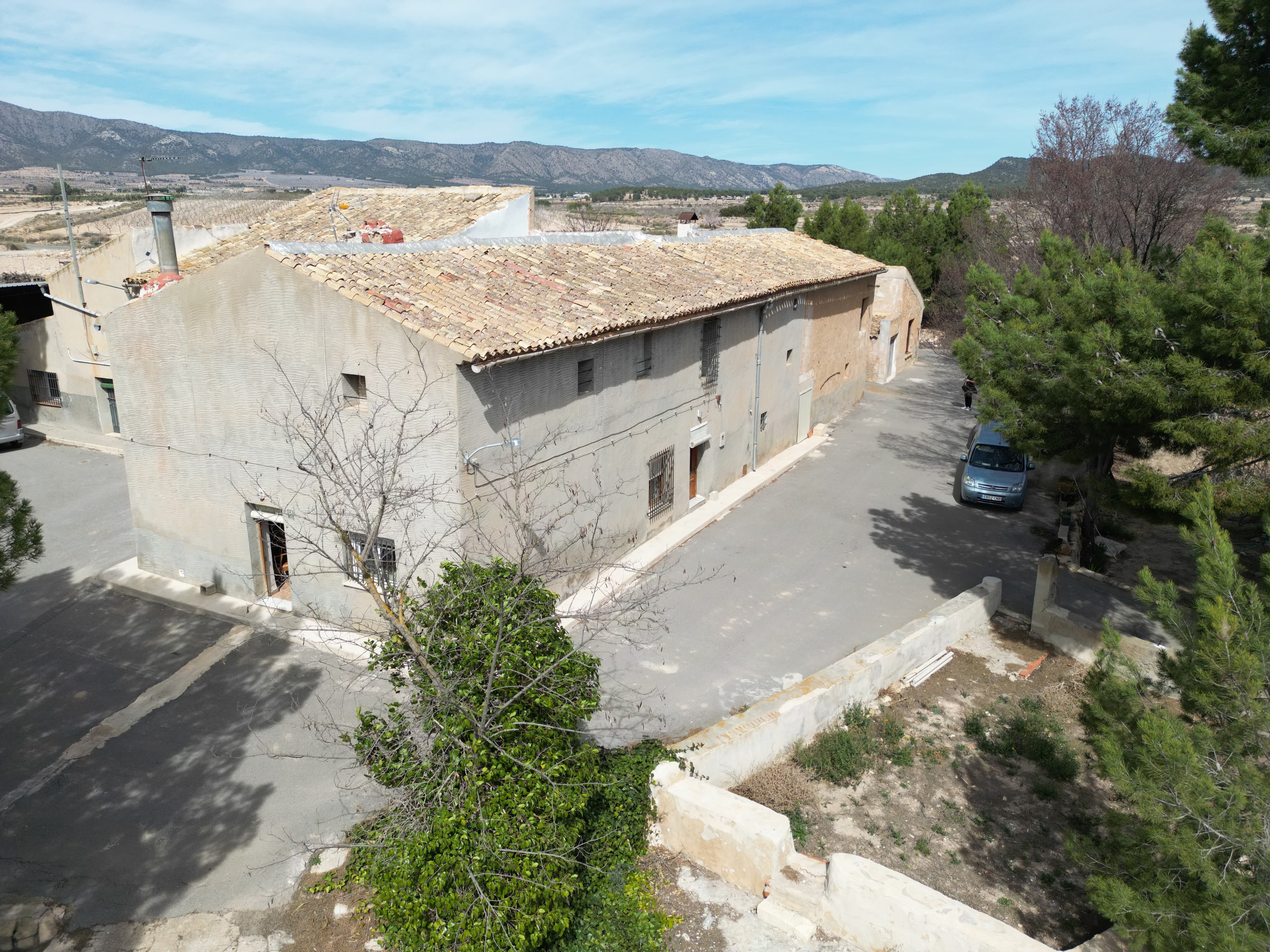 This remarkable rural estate presents a rare opportunity to acquire a substantial property combining two traditional country houses, extensive productive land, agricultural facilities, and exceptional potential for private, agricultural, hospitality, or investment use.Historically forming a single estate, the properties can be purchased together to recreate a large-scale country residence with significant landholdings and infrastructure. The estate offers an outstanding combination of privacy, character, productivity, and future possibilities in one of the most attractive rural areas of the Alicante province.The first house is a substantial traditional property with approximately 688 m² of constructed area, including the main residence, agricultural buildings, storage facilities, and a traditional wine cellar. The home currently offers six bedrooms, two spacious living rooms, a bathroom, and a fireplace, providing generous accommodation and ample scope for modernisation or conversion to suit a variety of uses.The second house retains the charm and authenticity of a traditional Spanish country home. Its accommodation is arranged over two floors and includes a living room, a sitting room with fireplace, kitchen, four bedrooms, a family bathroom, garage, and a traditional hayloft that could be transformed into additional living space. The property also benefits from a large courtyard and garden area with plenty of room for outdoor entertaining, leisure facilities, or landscaping projects.Together, the estate benefits from extensive outbuildings, garages, storage areas, agricultural facilities, a private water well, irrigation reservoir, mains electricity, and irrigation water connections. These features make the property equally suitable as a private residence, working agricultural estate, equestrian property, rural tourism business, boutique hospitality project, or multi-generational family home.The land is one of the property's most valuable assets. The estate comprises approximately 75,886 m² of land in total, including productive vineyards and olive groves currently in full cultivation. The combination of established agricultural production and substantial infrastructure creates an excellent opportunity for those seeking a lifestyle property with income-generating potential.The large courtyards, open views, and surrounding countryside provide a sense of space and tranquillity rarely found, while the possibility of owning both houses together offers flexibility for a wide range of residential and commercial projects.LocationThe estate is located in Fuente del Pino, a peaceful rural hamlet situated between the well-regarded towns of Pinoso and Monóvar. The area is renowned for its vineyards, olive groves, and beautiful open landscapes, offering a setting of exceptional privacy and natural beauty.Despite its tranquil surroundings, the property enjoys convenient access to all essential services, restaurants, shops, healthcare facilities, and local markets, with Pinoso just a short drive away. The region is highly regarded for its agricultural heritage, authentic Spanish character, and relaxed lifestyle, making it particularly attractive to international buyers seeking space, privacy, and a genuine connection to the countryside.This is a unique opportunity to acquire a significant rural estate with two homes, productive land, extensive infrastructure, and the potential to create an exceptional private residence or investment project in a highly desirable location.We have a large portfolio of properties in the Costa Blanca and Costa Calida areas, specialising in country properties, villas, fincas, building plots and design and build options in the Alicante and Murcia regions with a particular emphasis on Elda, Monovar, Pinoso, Sax, Villena, Aspe, Fortuna, Albacete and many more surrounding areas. We have been established since 2004 and have decades of experience between the team which we bring to bear to help you find and secure your new dream home. We help you every step of the way to make sure your purchase in Spain is safe and hassle free. We are not here to sell you a property, we are here to help you realise your dream and find what is right for you. With us you are in the safest hands. Contact us now to have a no obligation chat about how you too can realise your dreams.