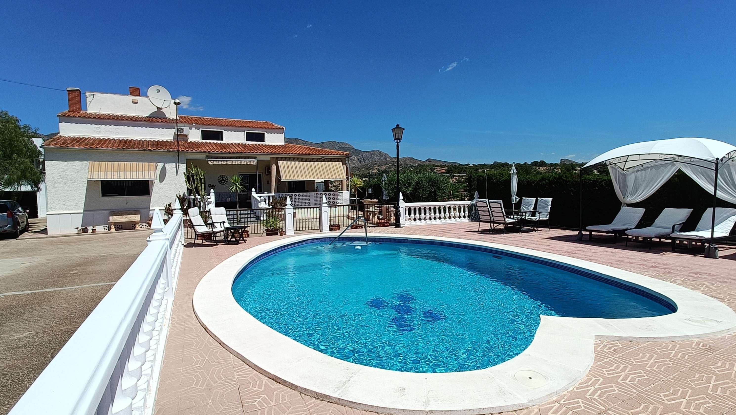 Stunning Detached Villa with Private Pool, Separate Guest Apartment, Garage & Underbuild on the Outskirts of CrevillentOutside SpaceEntering the property through the main gates, you are welcomed by a private driveway leading down to the expansive plot. To the left, there is a useful shed along with a fantastic entertaining area, ideal for drinks, BBQs, or spending quality time with family and friends.To the right, you will find the stunning heart-shaped private pool, surrounded by multiple sunbathing and relaxation areas where you can enjoy the spectacular 360-degree mountain views.Directly in front of the villa is a large outdoor space, part of which has been transformed into a charming seating area featuring artwork from the current owners. To the left sits the garage, which comfortably accommodates one vehicle, and above this is a separate storage room with its own private access from the main road. The previous owners used this space to bake and sell fresh bread, meaning it offers fantastic potential for a hobby business, studio, or additional storage.The garden wraps around the entire property, ensuring beautiful outdoor spaces wherever you are, all complemented by stunning views across the surrounding countryside and mountains of Crevillent.Main HouseWalking up the main staircase, you are greeted by a spacious terrace area, perfect for relaxing outdoors. Entering the villa, you arrive in a welcoming hallway that provides access to all rooms on the ground floor.To the left is a very large fully fitted kitchen, offering extensive storage space and an ideal layout for large families or those who enjoy entertaining guests. The property also benefits from a bright and spacious living area, filled with natural light thanks to the multiple windows throughout the room.Further down the hallway is a separate dining room, which was originally designed as a bedroom but is currently used as an additional dining and entertaining space by the owners. On this floor, there are also two generously sized bedrooms, one of which benefits from built-in wardrobes, along with a large family bathroom.Climbing the stairs to the first floor, you arrive at a spacious foyer area that has been transformed into a second living room. On this level, there are two further large bedrooms, both featuring walk-in wardrobes and en-suite bathrooms. Each bedroom enjoys beautiful views, while the large windows flood the spaces with natural light.Another added bonus of the property is the very large underbuild, which offers excellent potential for a variety of uses, as well as providing substantial storage space.It also features a charming wine cellar, complete with a beautiful mosaic designed by the current owners, adding a unique and personal touch to the property.Private ApartmentTowards the rear of the property is a fully self-contained apartment, ideal for guests, extended family, or potential rental opportunities. The apartment offers a spacious living room, a cosy kitchen, a large bathroom, and a comfortable bedroom.Again, thanks to the large windows throughout, the apartment feels bright and airy while also benefiting from excellent storage space.About CrevillentLocated at the foot of the stunning mountains of the Costa Blanca, Crevillent is a traditional Spanish town known for its peaceful surroundings, beautiful countryside views, and authentic charm. The town offers a wide range of local amenities including shops, restaurants, schools, and cafés, while still being within easy reach of the beaches of the Costa Blanca, Alicante Airport, and several major cities. It is the perfect location for those looking to enjoy a quieter lifestyle while remaining well connected.